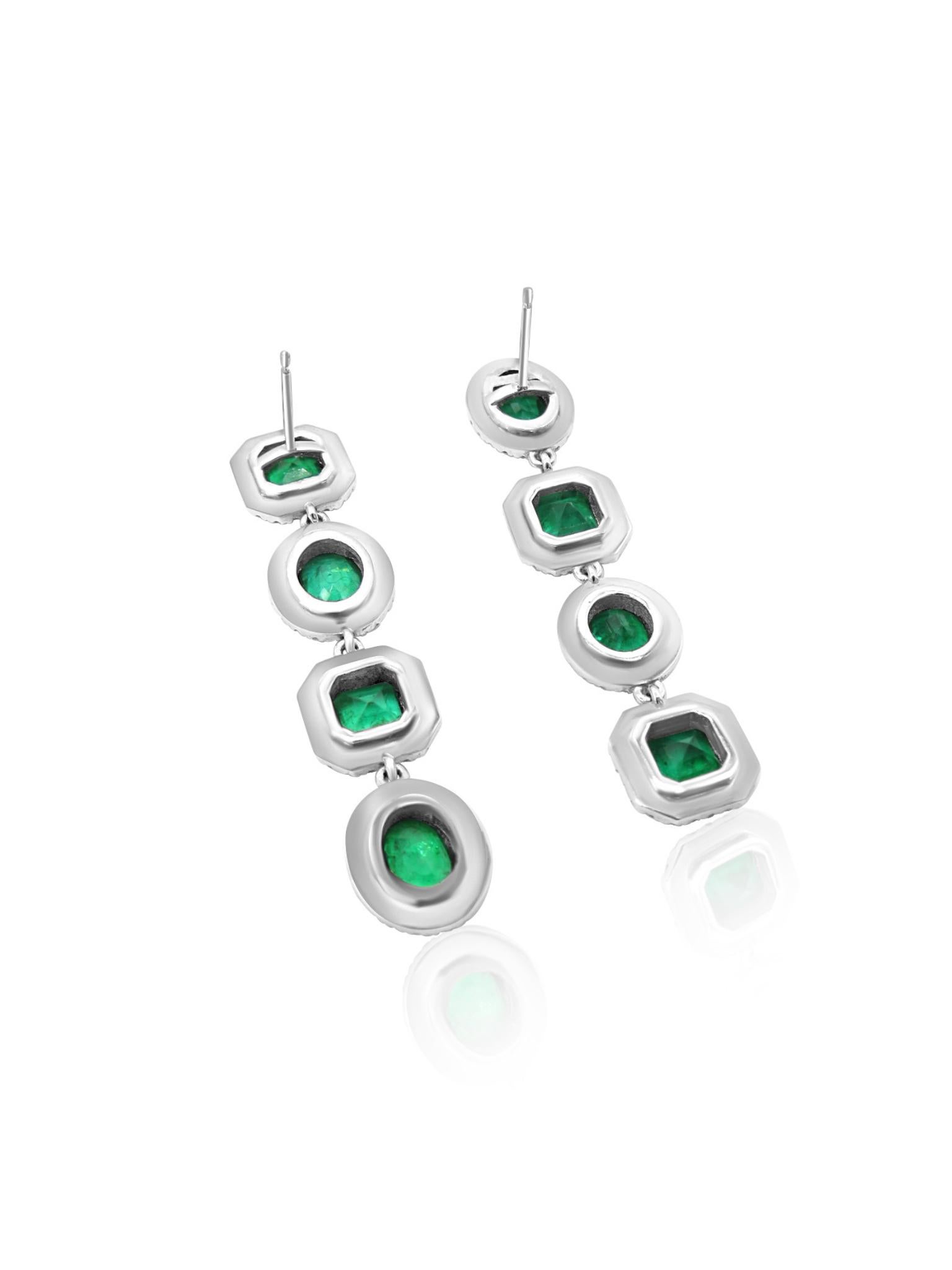 Diese Tropfenohrringe aus 18 Karat Weißgold bestechen durch ihre anmutige Anordnung von Smaragden und Diamanten in einem kaskadenartigen Design. Jeder Smaragd wird von einem zarten Brillantkranz umrahmt, der den leuchtenden Grüntönen ein dezentes