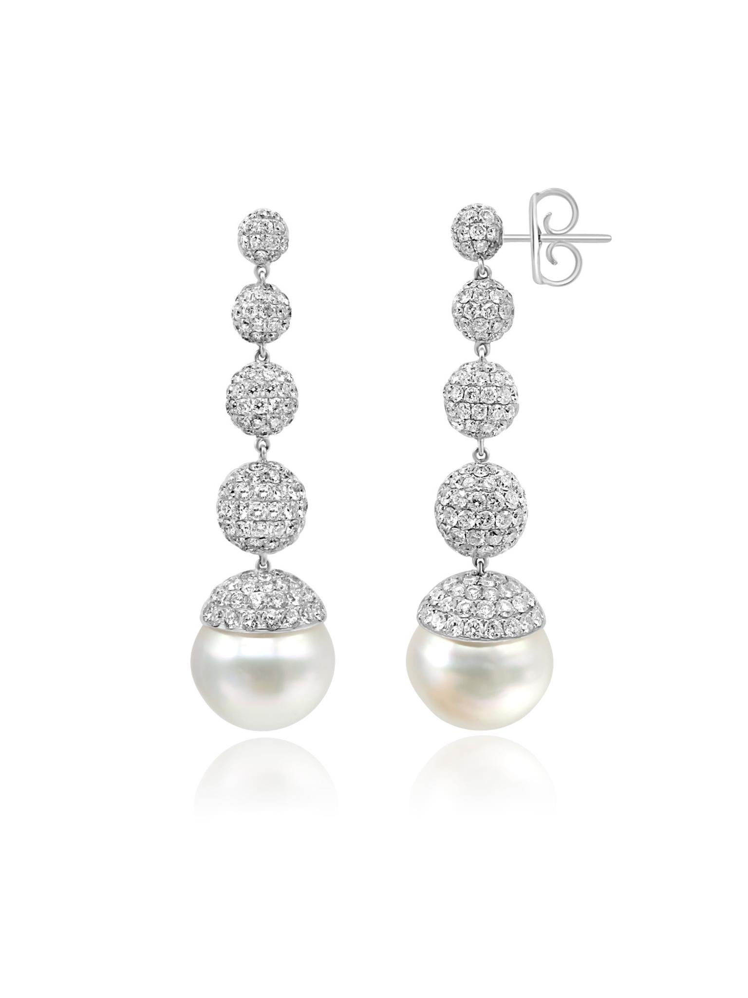 Eleganti orecchini realizzati in oro bianco 18 carati con uno splendido design a goccia graduata. Gli orecchini sono impreziositi da tre sfere con pavé di diamanti, ognuna progressivamente più piccola, che sfociano in una grande e lucente perla