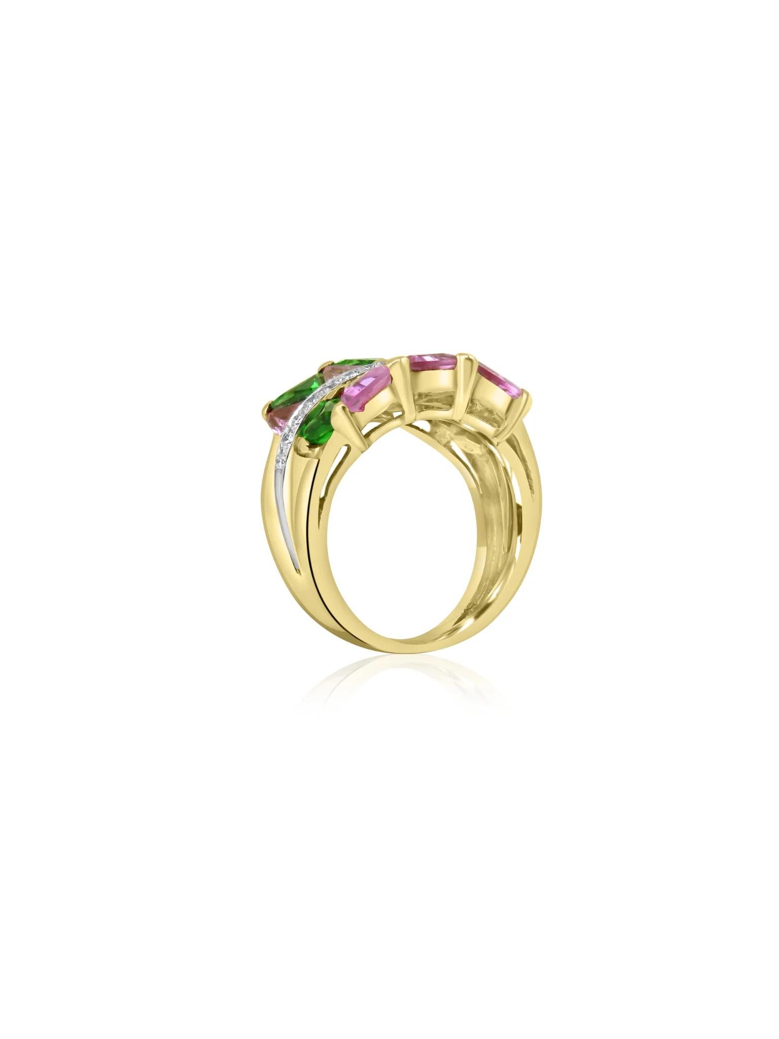 This Mozafarian 18 karat yellow gold ring features a striking combination of stunning trillion-cut tsavorites and pink sapphires, artfully arranged in a playful and dynamic design. Accentuating the vibrant gemstones, a dazzling line of diamonds is