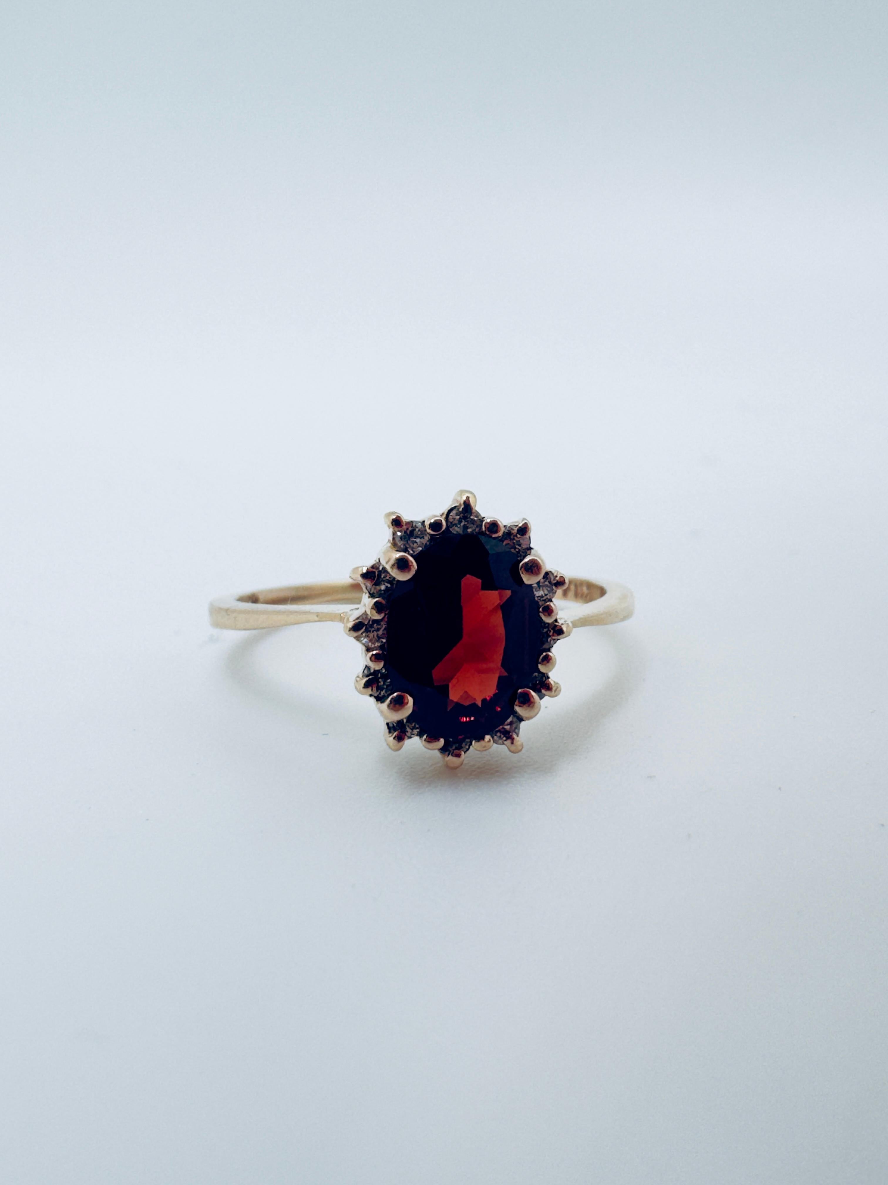 Questo elegante anello è realizzato in oro giallo 14K e combina un design classico con una raffinata ricercatezza. Al centro, un granato rosso del Mozambico di 8x6 mm è splendidamente incastonato in una montatura a coperchio, che mette in risalto il