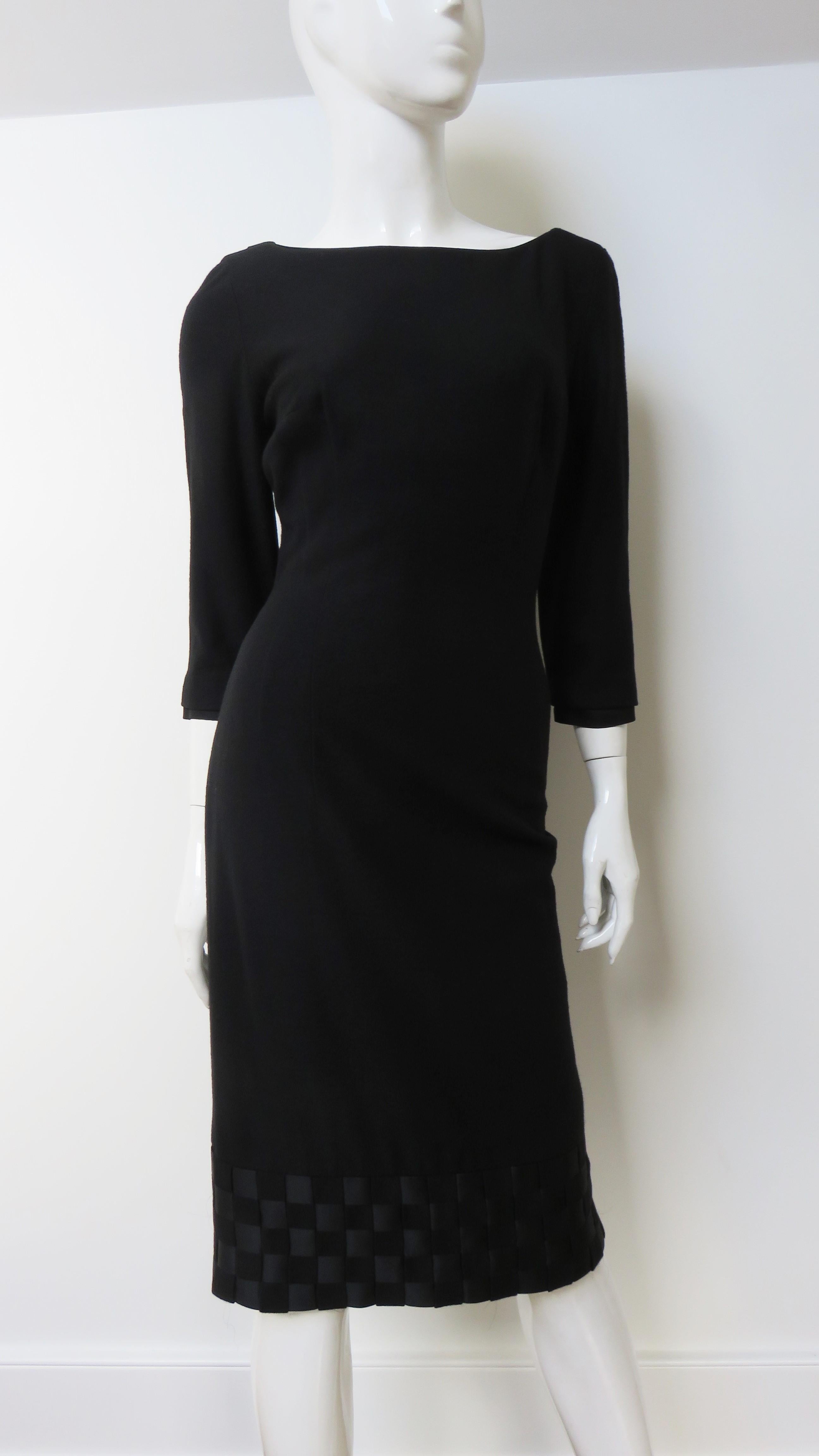 A fabulous black jersey dress by Mr. Blackwell.  It is a semi fitted sheath with 3/4 length sleeves and a collar that dips lower in the back.  The collar and 5