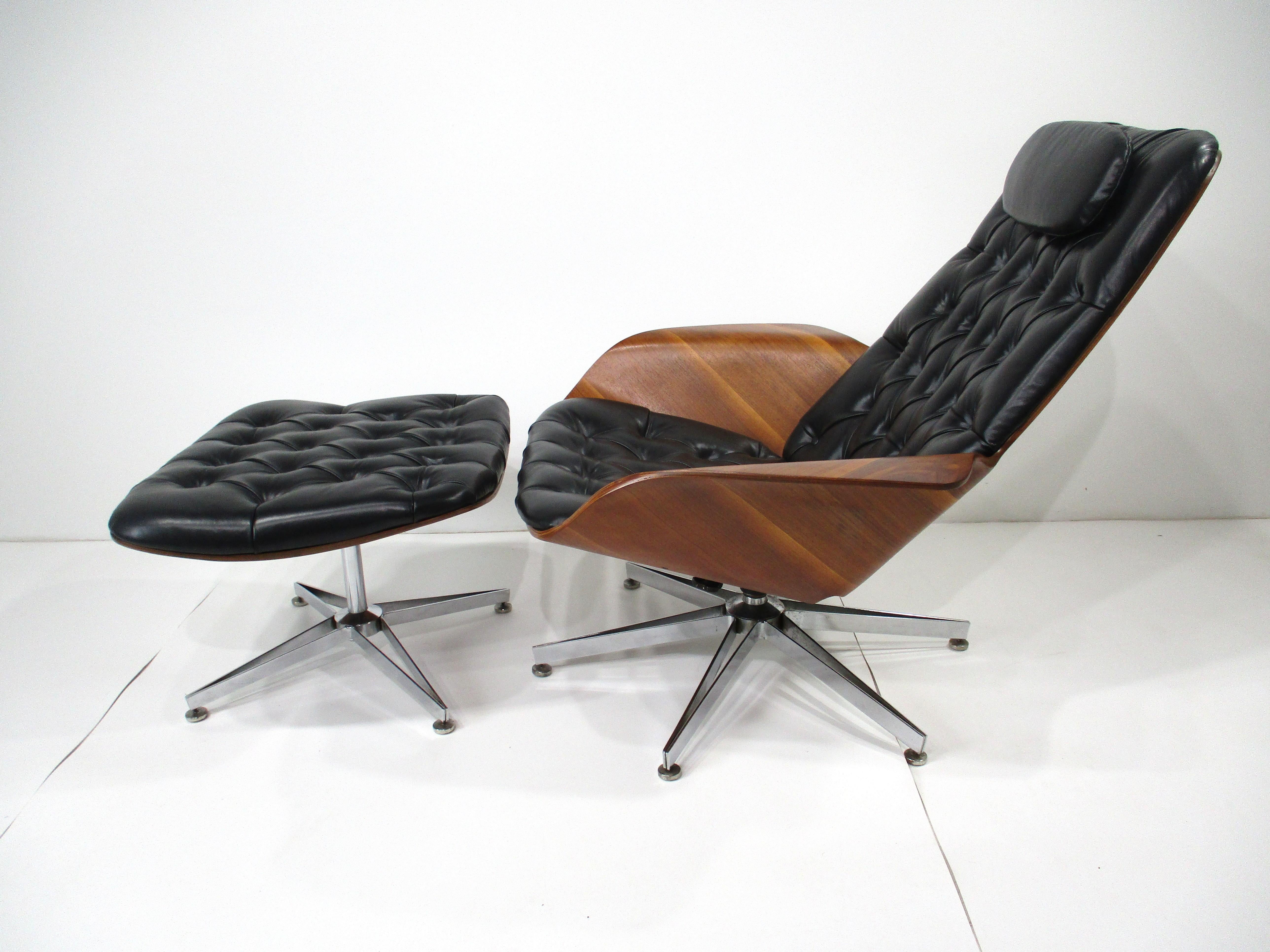 Une chaise de salon exceptionnelle en noyer et en cuir noir moelleux et touffeté, ainsi qu'un ottoman assorti appelé Mr. Chair par le fabricant Plycraft . La chaise pivote et peut se balancer un peu grâce à son mécanisme à ressort, contrairement à