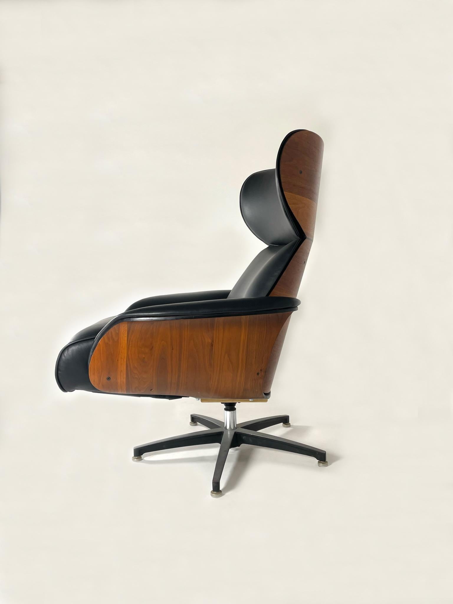 Il s'agit d'un fauteuil inclinable Mr. Chair, rarement vu, avec ottoman intégré. Nouvellement retapissé en cuir italien noir neuf. Il s'agit d'une variante très rare de la chaise Mr Chair. Elle a été conçue pour avoir une empreinte de pied plus