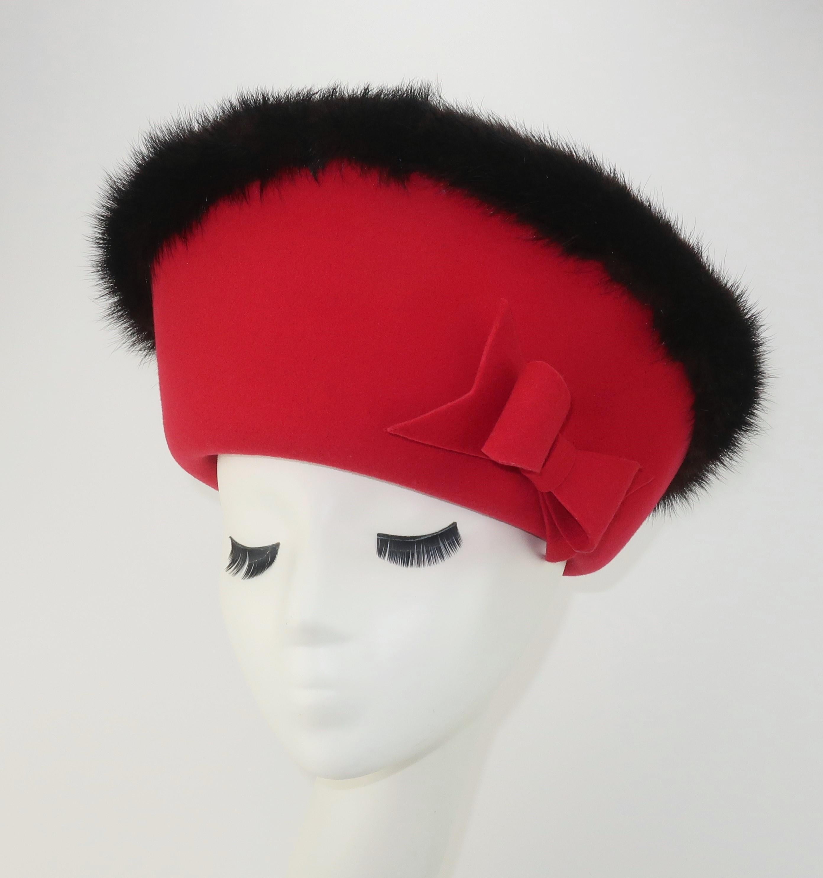 1960's Mr. John Jr. red wool hat with the fabulous presence of a crown.  The grand silhouette is enhanced by dark brown (almost black) mink fur trim and a girlish bow.  Mr. John hats were created by milliner, John Harberger, who was part of the