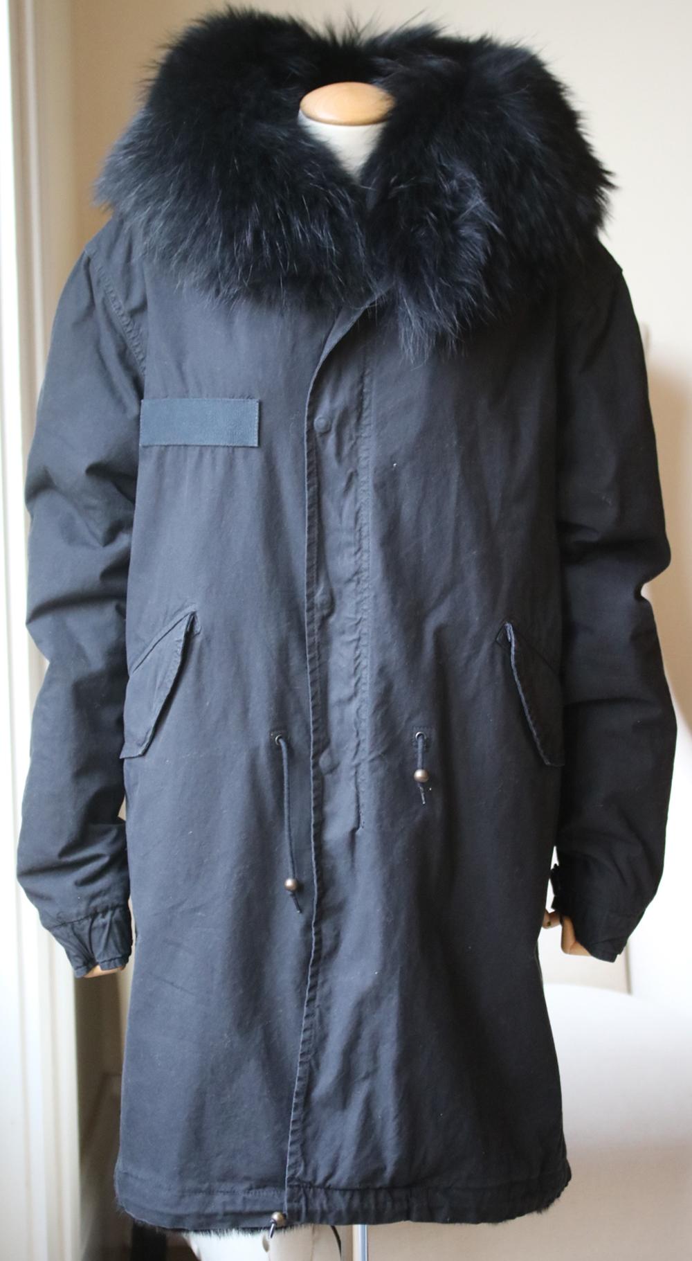 The iconic Mr&Mrs Italy Parka opts for a sumptuous Total Black look. The military-inspired design in cotton canvas is fully lined with rabbit fur in. Removable raccoon fur-trim hood. Long sleeves with button-fastening cuffs. Flapped front pockets.
