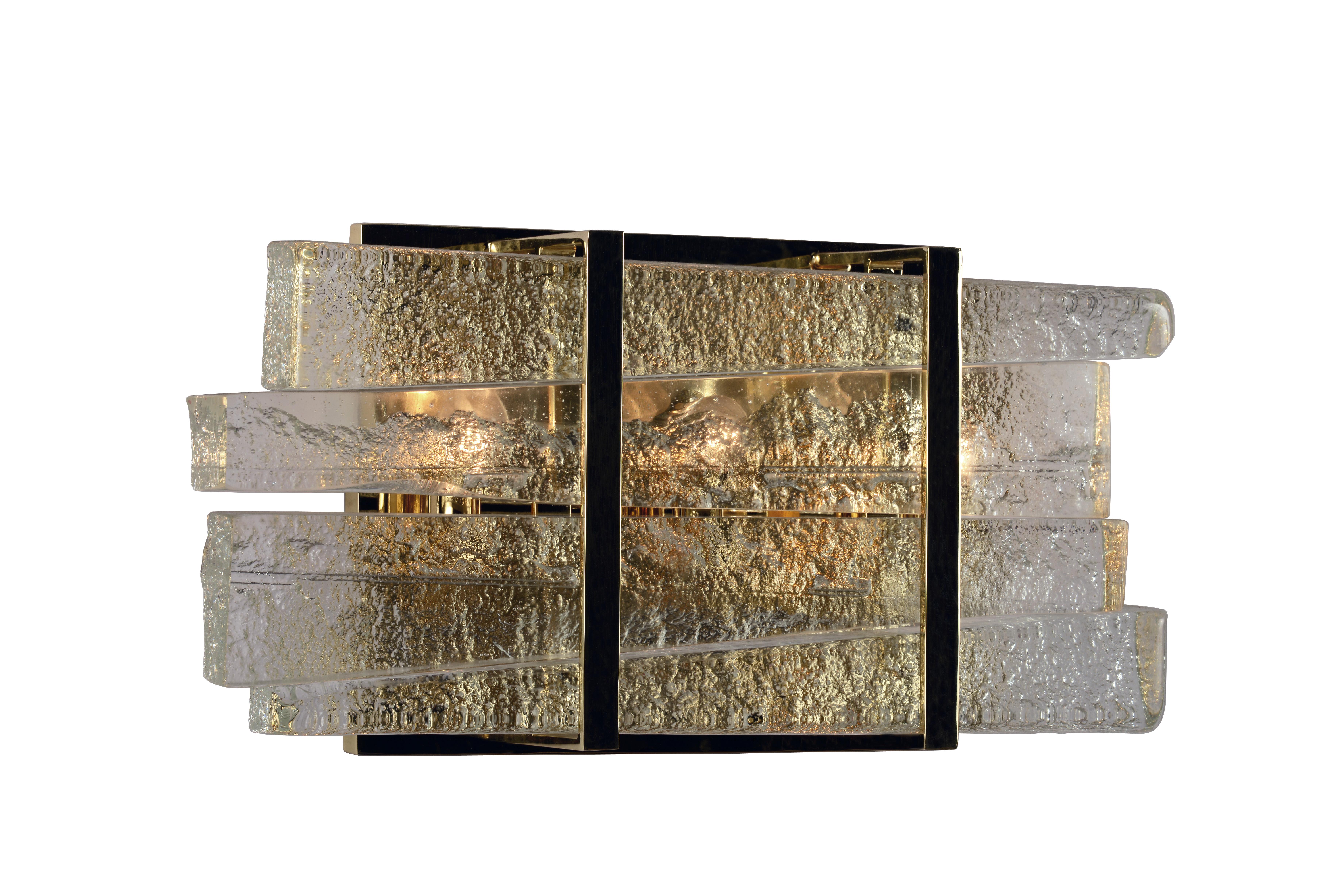 Rough-hewn blades of sand cast glass are stacked within refined architectural bands of mirrored brilliant bronze or natty nickel.

Models in the collection are individually hand-crafted by the skilled artisans in our studio. Custom versions tailored