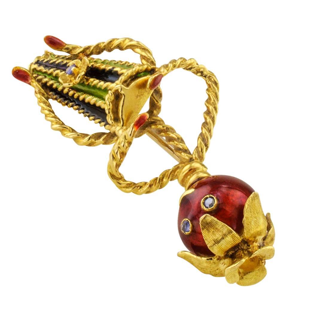 1960s conga drum player enamel and sapphire gold brooch. Handcrafted in 18-karat yellow gold, the whimsical design features a very animated tomato marking the beat on a conga drum, sapphire-set eyes and drum, green, blue and red enamel accents