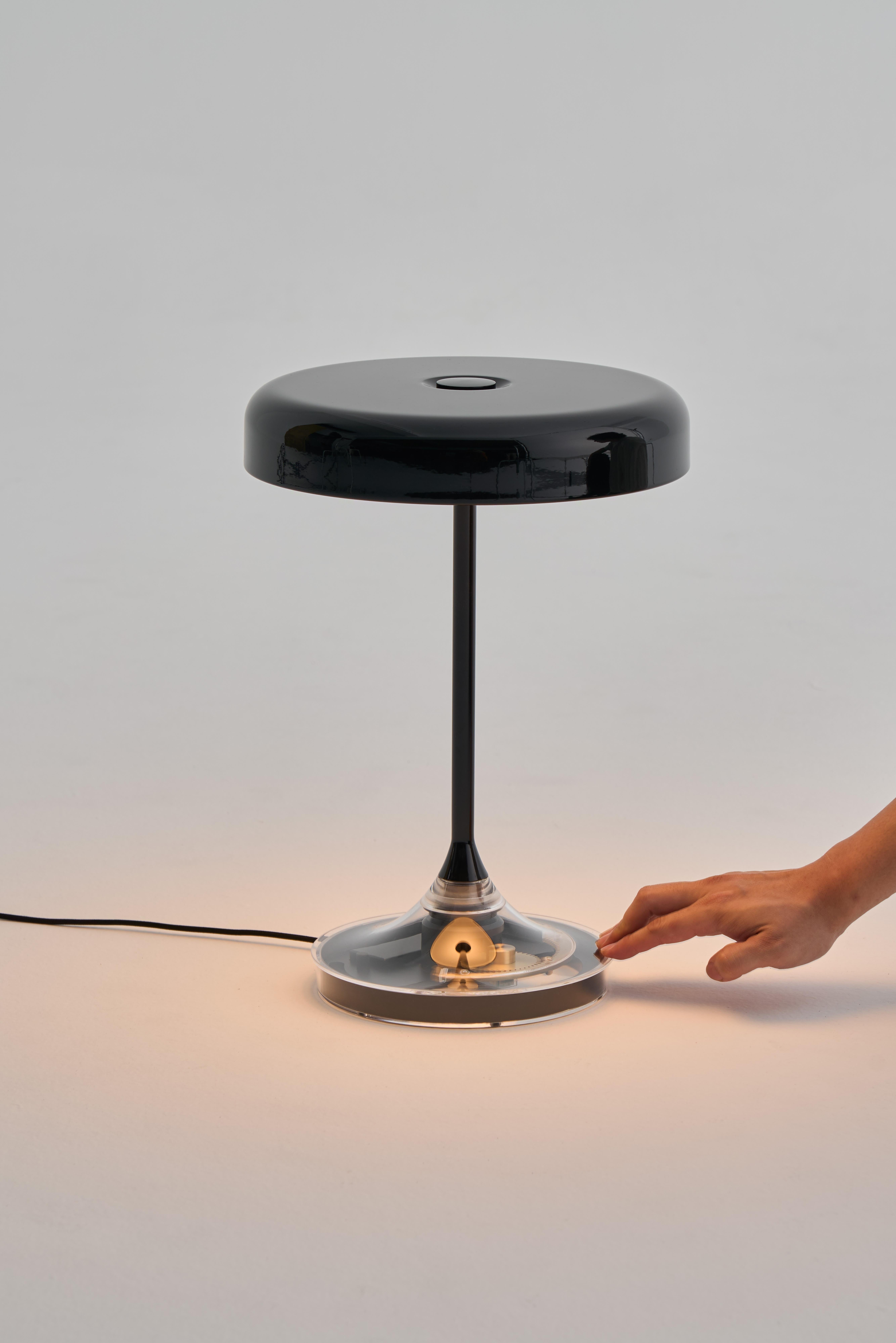 La lampe de table Mr. DJ fait ses adieux aux interrupteurs conventionnels et présente un design innovant avec sa base rotative intégrée pour un réglage sans effort de la luminosité. La base est fabriquée dans un matériau translucide, ce qui permet