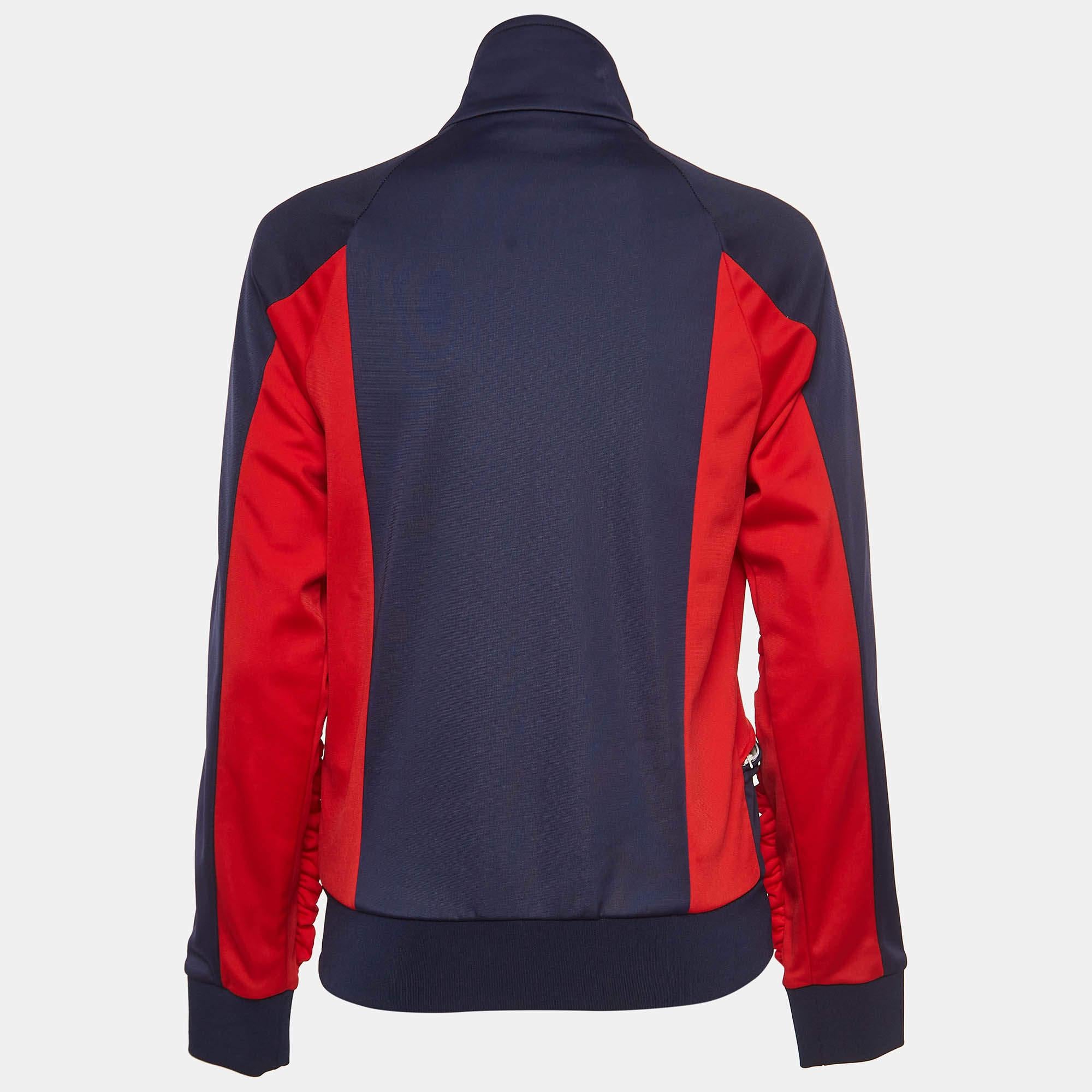 The MSGM jacket is a stylish blend of sporty and feminine elements. Crafted from jersey fabric, it features a bold color contrast, ruffle detailing for a playful touch, and a classic bomber silhouette, making it a chic and contemporary wardrobe