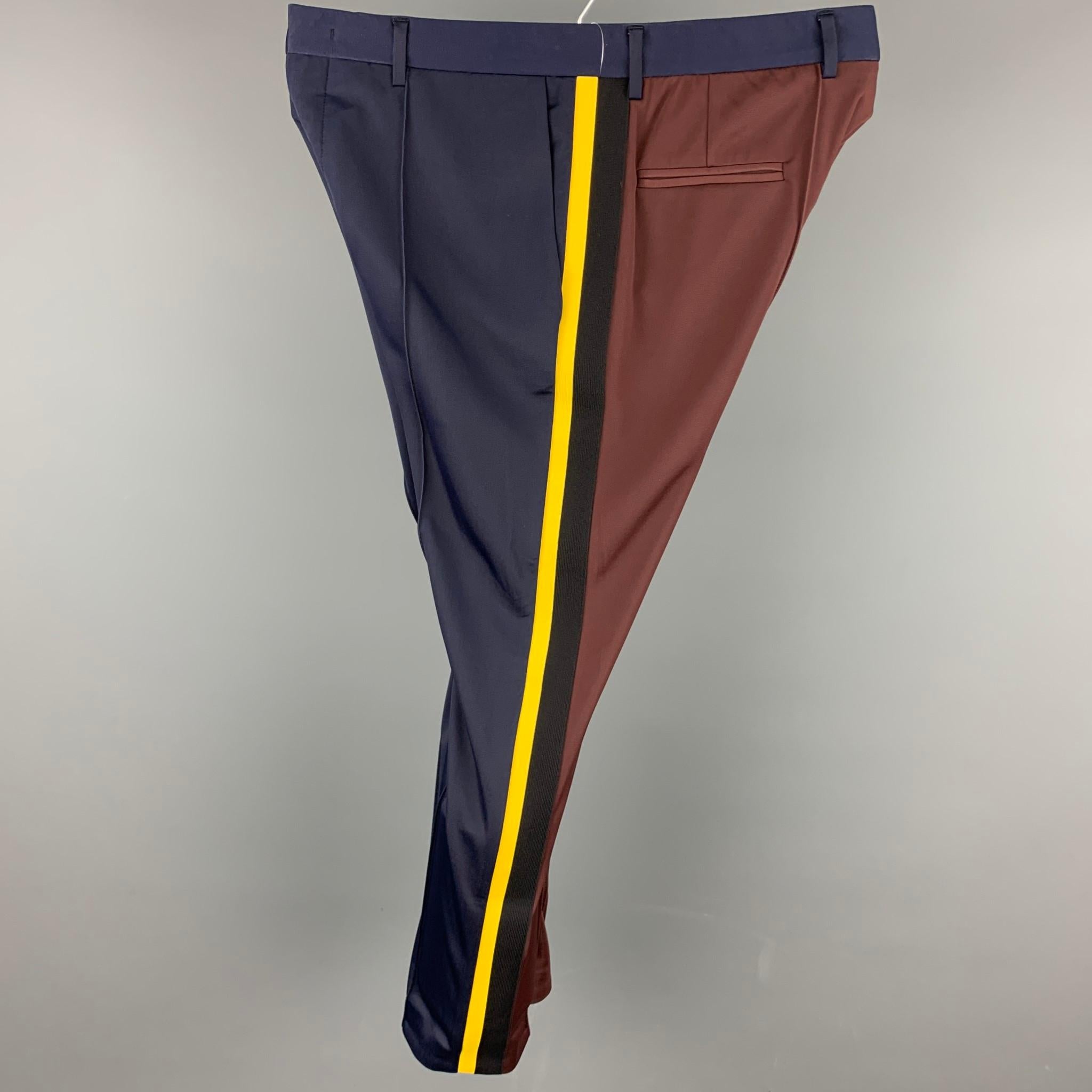 MSGM casual pants comes in navy & brown color block polyester / polyamide with a yellow stripe design featuring a slim fit, front tab, and a zip fly closure. Made in Italy.

Very Good Pre-Owned Condition.
Marked: IT 52

Measurements:

Waist: 36
