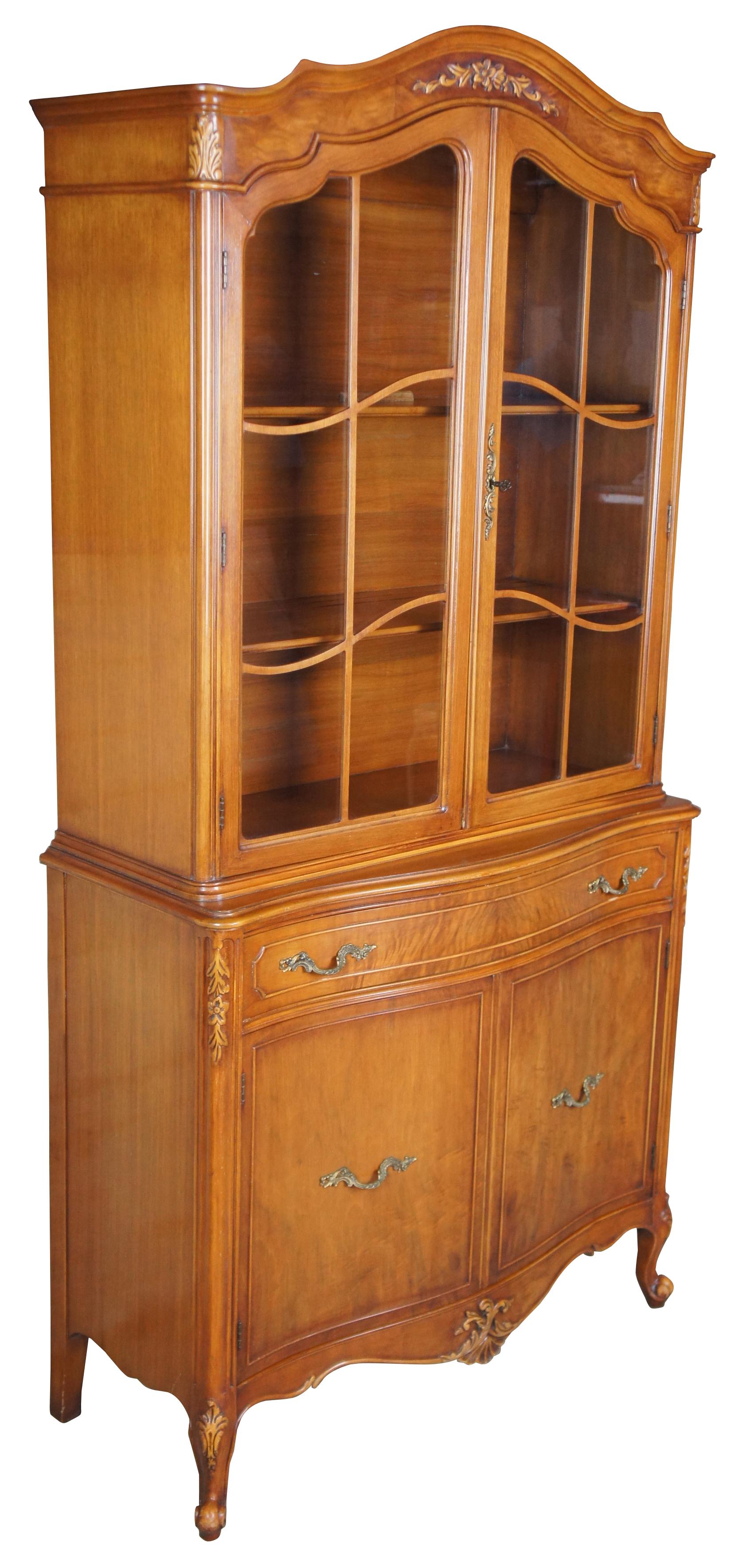 Mount Airy china cabinet, circa 1940s. Made from walnut with a serpentine front and crotch veneered drawers. Features carved accents, scalloped brass hardware and cabriole legs.

Mount Airy of North Carolina's roots go back to 1888 when the lumber