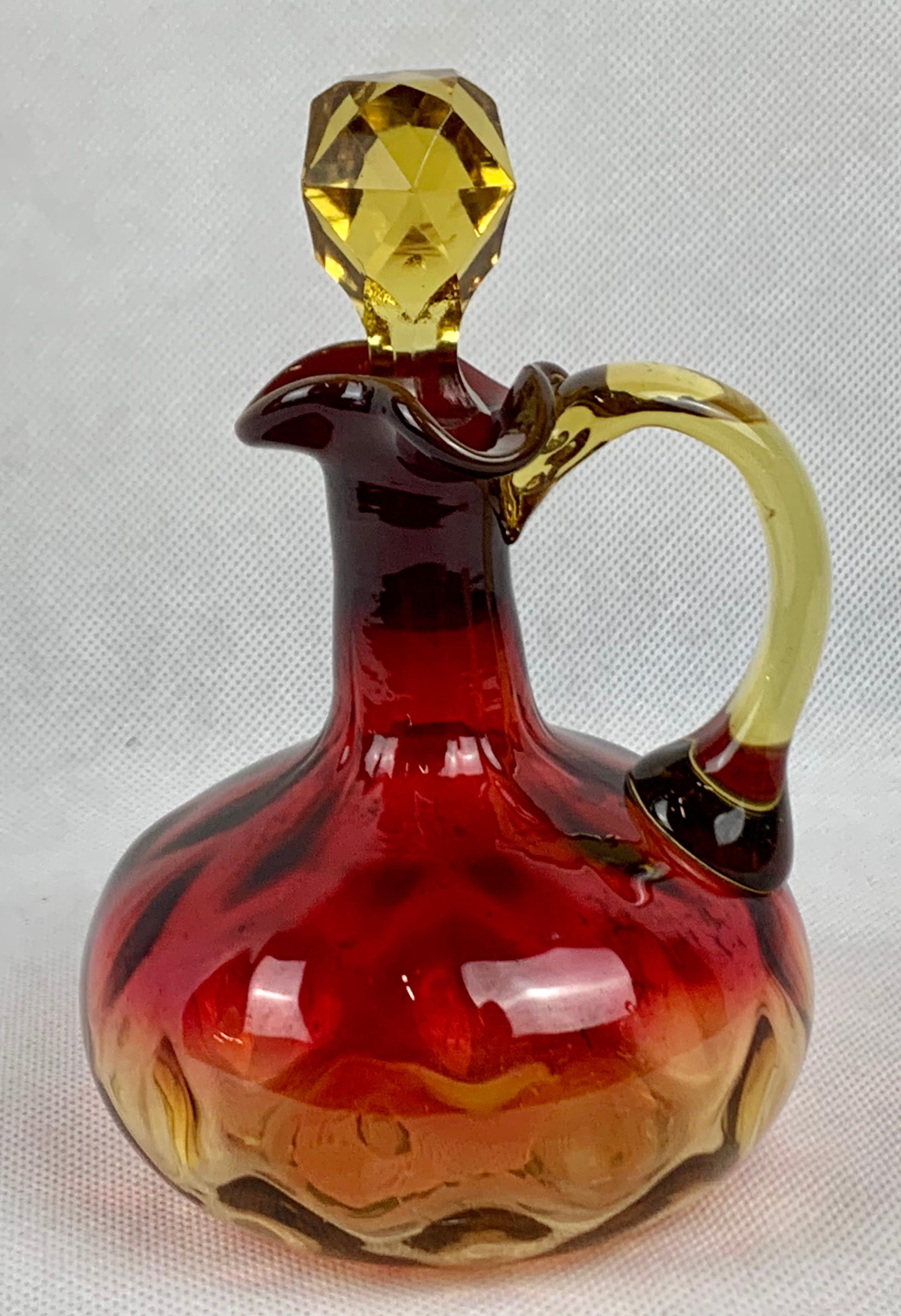 Amberina cruet attributed to the Mount Washington Glass Company. The color was created in 1883 by Joseph Lock by adding gold powder to amber glass. The body is in the inverted thumbprint pattern with a polished pontil on the base. The color fades