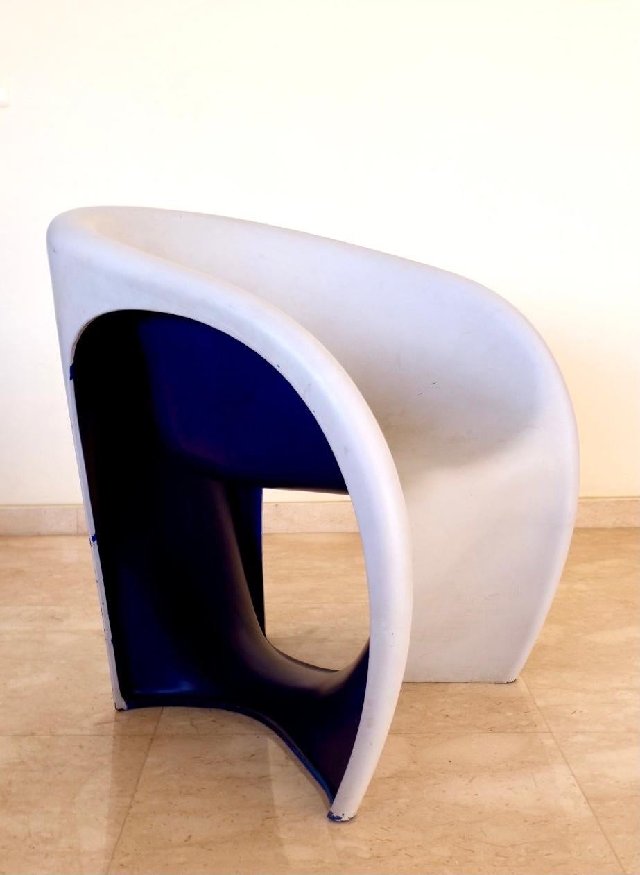 Dieser Sessel aus Polyethylen in sandweißer Farbe und fliederfarbener Innenausstattung hat eine bequeme Sitzfläche und ist mit einer Produktionsmarke unter dem Sockel versehen.