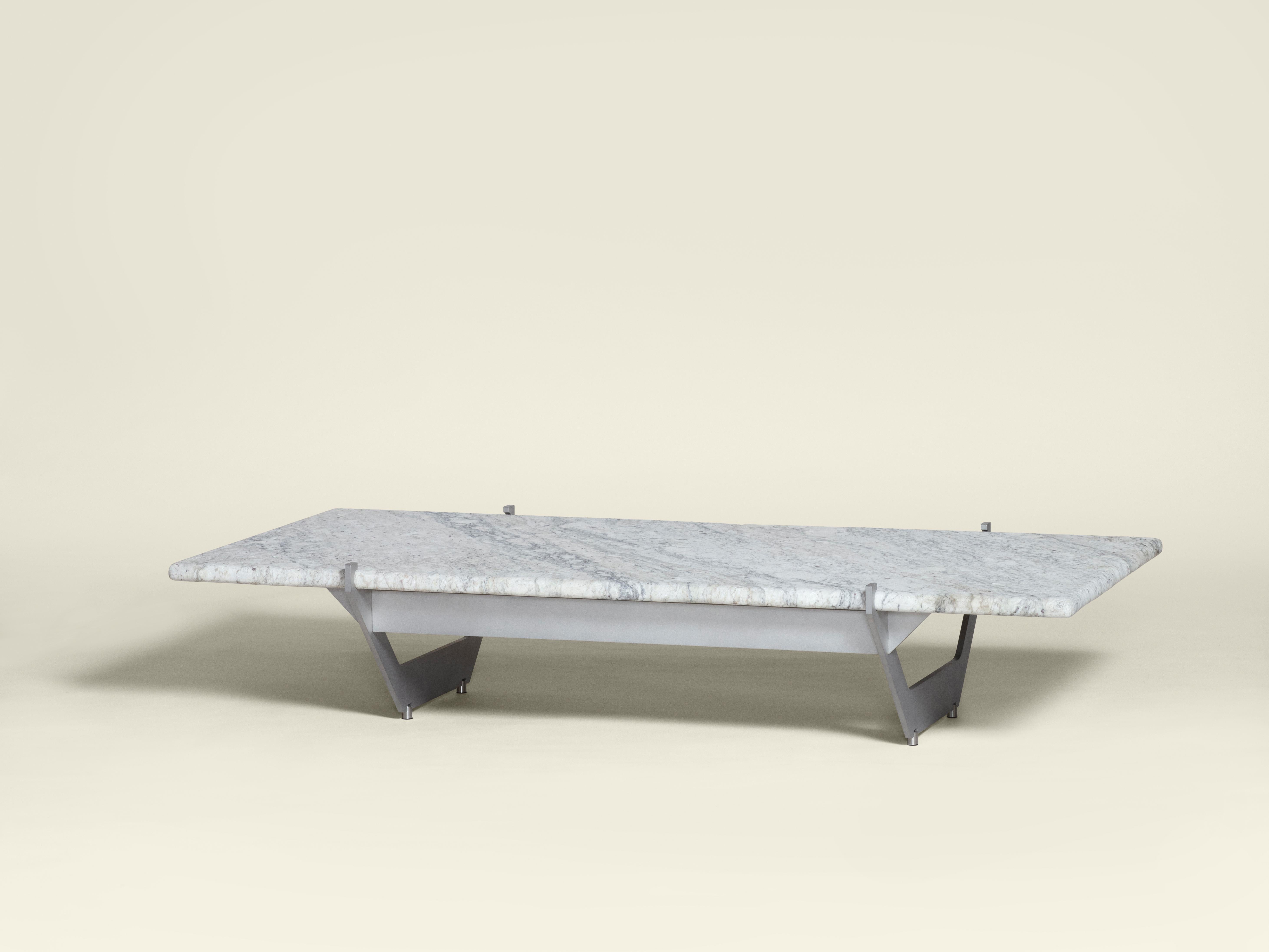 Der Couchtisch MŪ311 lässt sich von den flächigen Qualitäten des Unterbaus des Bettes MŪ11 inspirieren und interpretiert das Design mit einer Kombination aus Stahl und Stein neu. Die Art und Weise, wie die steinerne Tischplatte auf dem Sockel