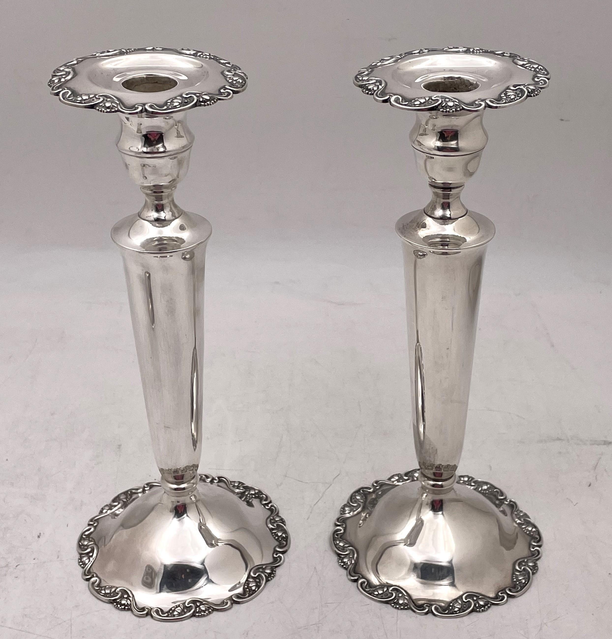 Mueck Carey pair of sterling silver candlesticks with stylized floral and geometric motifs and with removable bobeches. They measure 10 1/4'' in height by 4 1/3'' in diameter at the base, are weighted, and bear hallmarks as shown. Perfect for