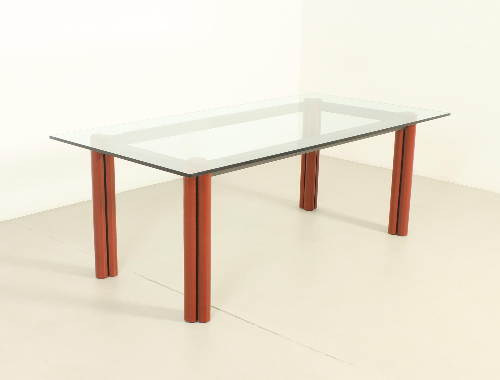 Mugello dining table designed in 1987 by Lodovico Acerbis and Giotto Stoppino for Acerbis International, Italy. Lacquered iron structure with aluminum legs sheathed with leather covers and a clear glass top. 