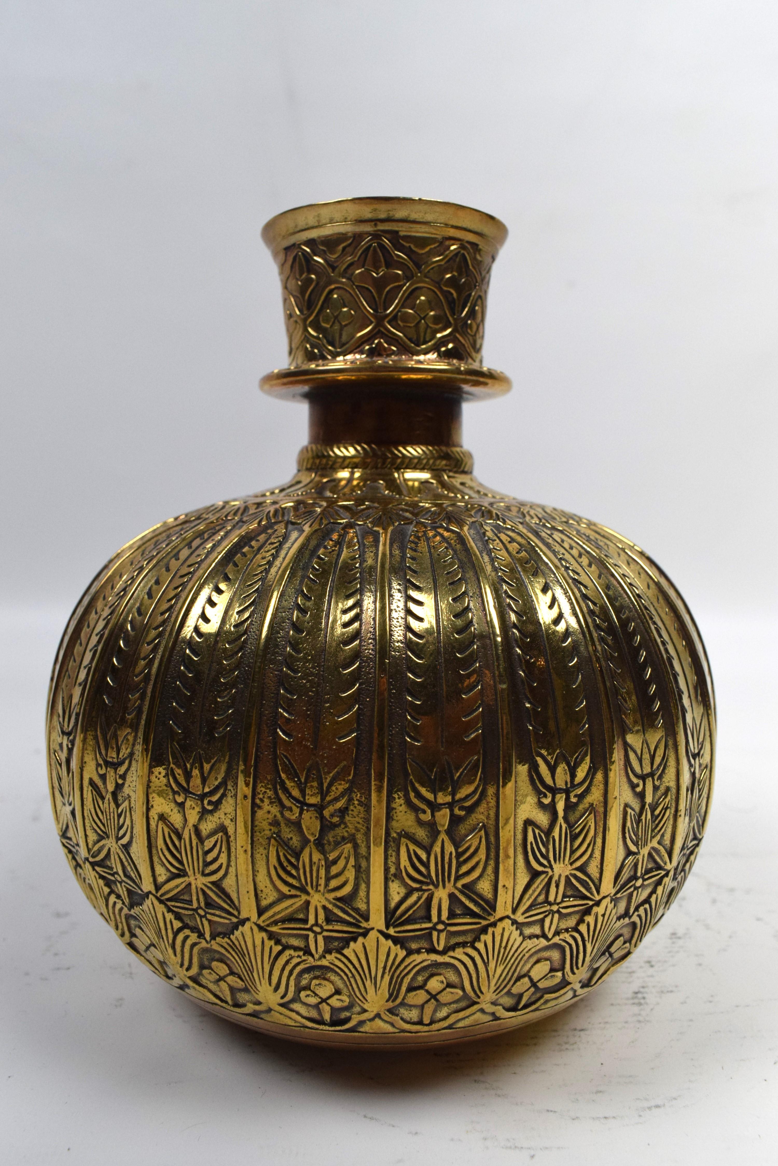 Le narguilé Mughal en laiton est doté d'une base en laiton magnifiquement gravée et ornée de motifs floraux complexes.  motifs géométriques. La base est une œuvre d'art, mettant en valeur l'artisanat exquis et le souci du détail caractéristiques du