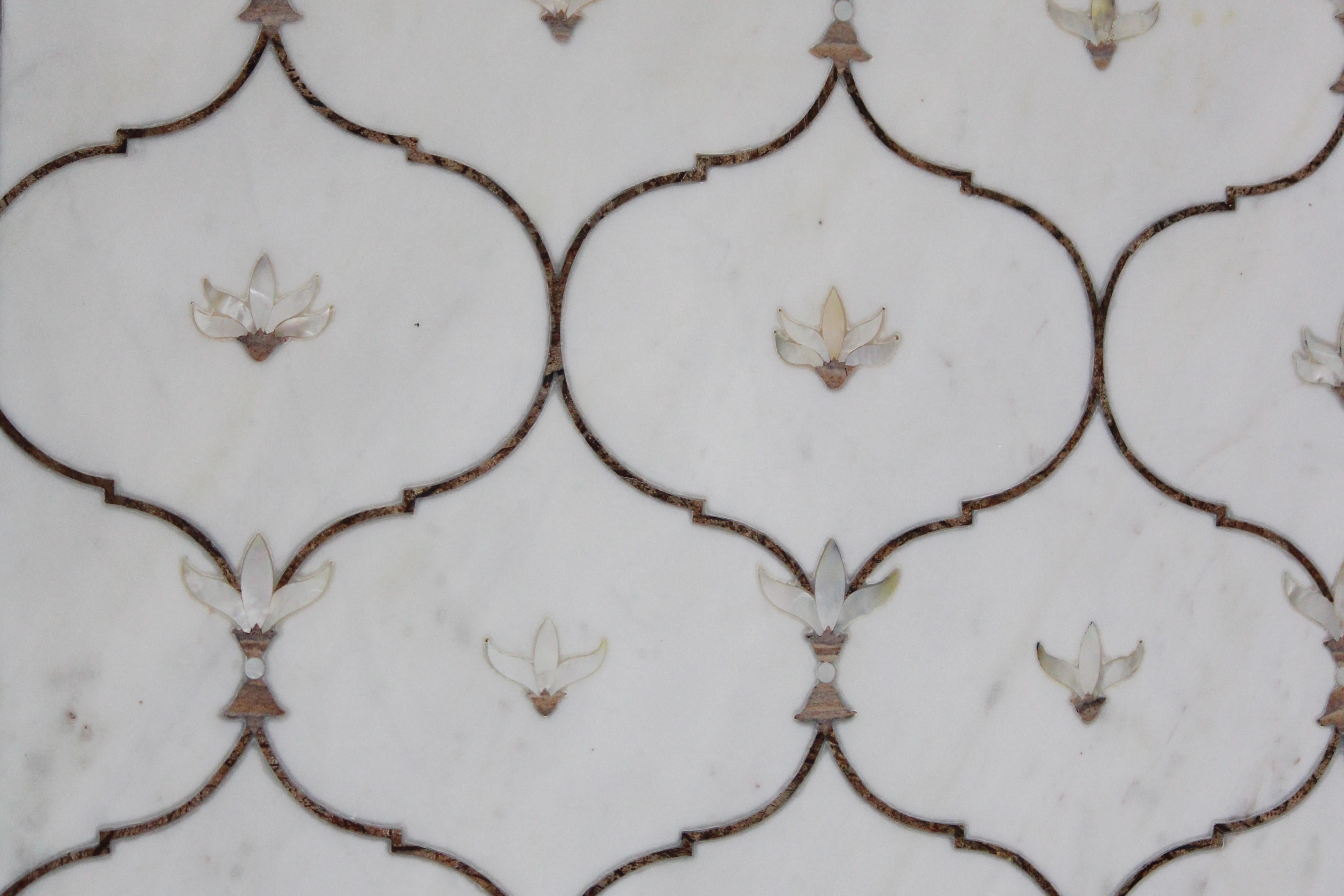 This stunning dining table top exhibits one of the most striking motifs of the mughal architecture in India. The lotus motif is inlaid using mother of pearl on the whitest of the marble using the centuries old technique of pietra dura / pacchikari.