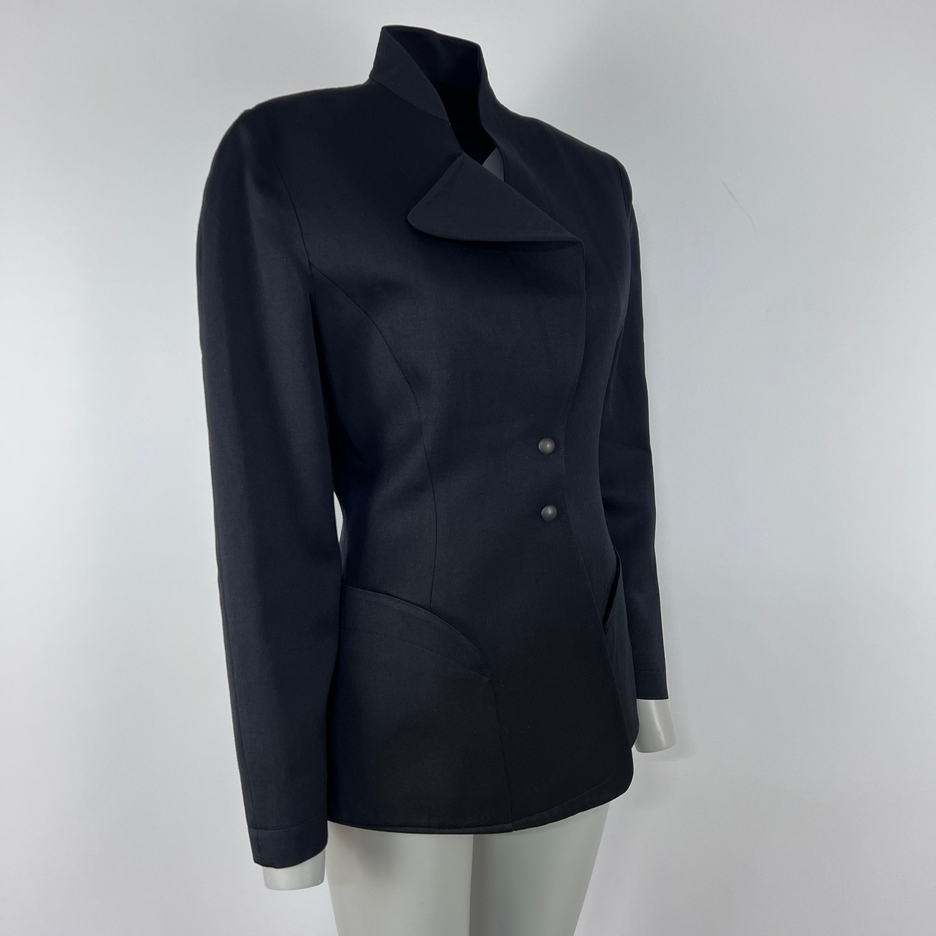 Veste MUGLER structurée en coton noir, années 1990. Fabriquée en France, taille indiquée 40 FR, convient pour une taille S d'après les mesures. Coupe précise et profil raffiné, facile du jour au soir. Longueur : 70 cm. État : Excellent.