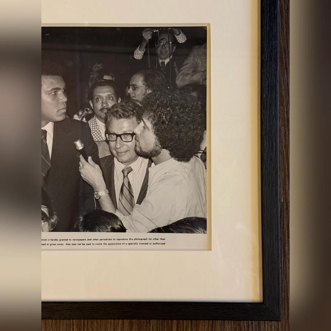 Muhammad Ali als Cassius Clay (1975) - FRAMED
Foto Standbild (8 X 10 Zoll)

Original s/w-Werbung noch #148.

Dieses Schwarz-Weiß-Foto zeigt Muhammad Ali, früher bekannt als Cassius Clay, während einer Pressekonferenz. Das Bild spiegelt seine