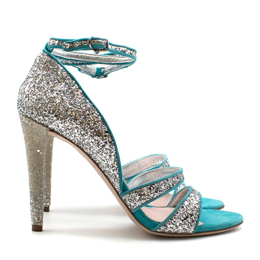 Mui Mui Blue Glitter Sandals

Miu Miu glitter electric blue 
Strappy sandals
Turquoise suede with silver glitter detailing 
Ankle strap
Double strap around toes
Yellow heel with silver glitter
Grey suede on interior 
Nude sole and insole 
Box