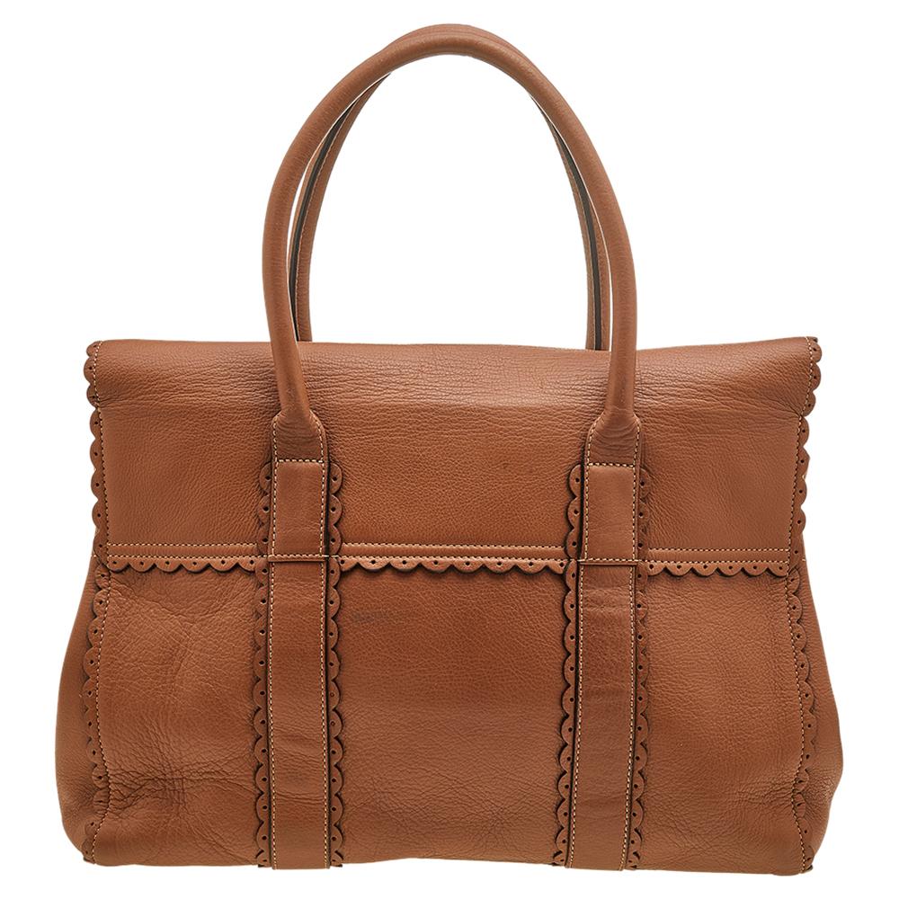 This Bayswater satchel from Mulberry, with its precise structure and functional design, ensures maximum practicality and convenience. It is made from brown scalloped leather, with a gold-toned lock closure perched on the front. It has dual handles