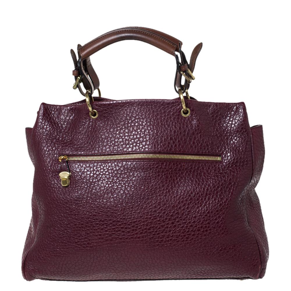 Designed with grained leather, this Polly tote is a reliable accessory. The fabric-lined interior of this handbag will keep your essentials safe. This elegant handbag is equipped with a front flap pocket secured by a push lock and a top handle.
