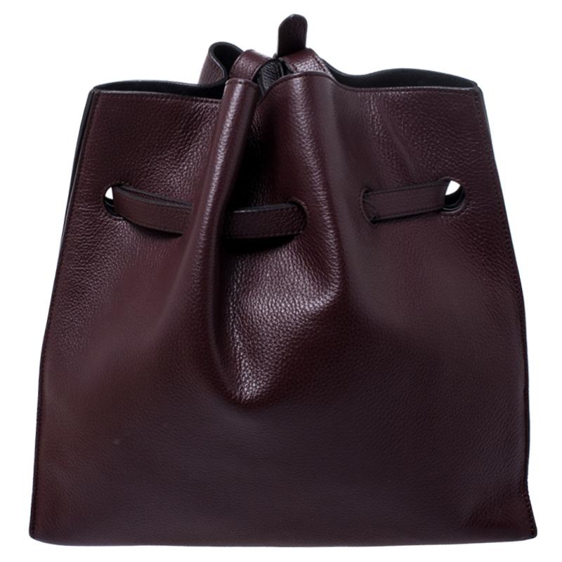 This beautifully designed bag by Mulberry is crafted from leather and comes in a lovely shade of burgundy. This Tyndale shoulder bag has a lovely silhouette, features a drawstring strap with turn-lock closure. The suede interior is spacious while