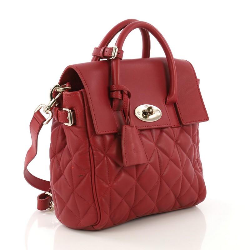 This Mulberry Cara Backpack and Shoulder Bag Quilted Leather Mini, crafted in red quilted leather, features dual rolled leather top handles, detachable straps, and gold-tone hardware. Its turn-lock closure opens to a red suede interior with zip