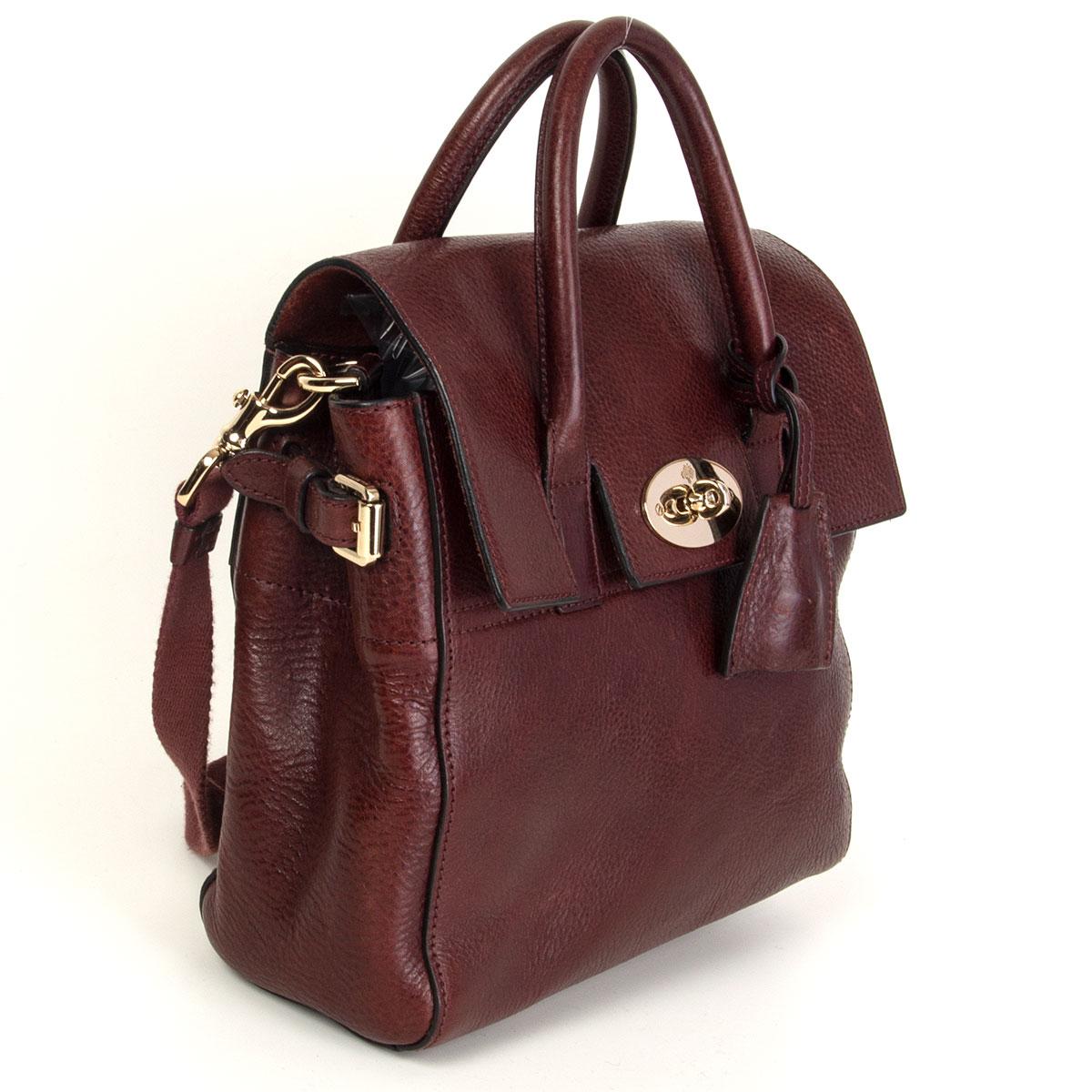 Mulberry x Cara Delevinge mini backpack in deep burgundy grained calfskin. Opens with the classic turn-lock to an unlined interior and one zipper pocket against the back. Comes with canvas adjustable backpack straps. Has been carried and is in