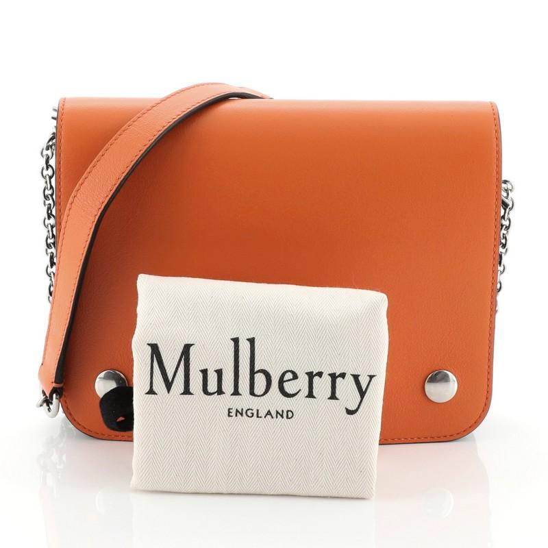 This Mulberry Clifton Crossbody Leather Medium, crafted in orange leather, features chain-link strap with leather pad, a full frontal flap and silver-tone hardware. Its snap closure opens to a three zip compartment green jersey interior. These are