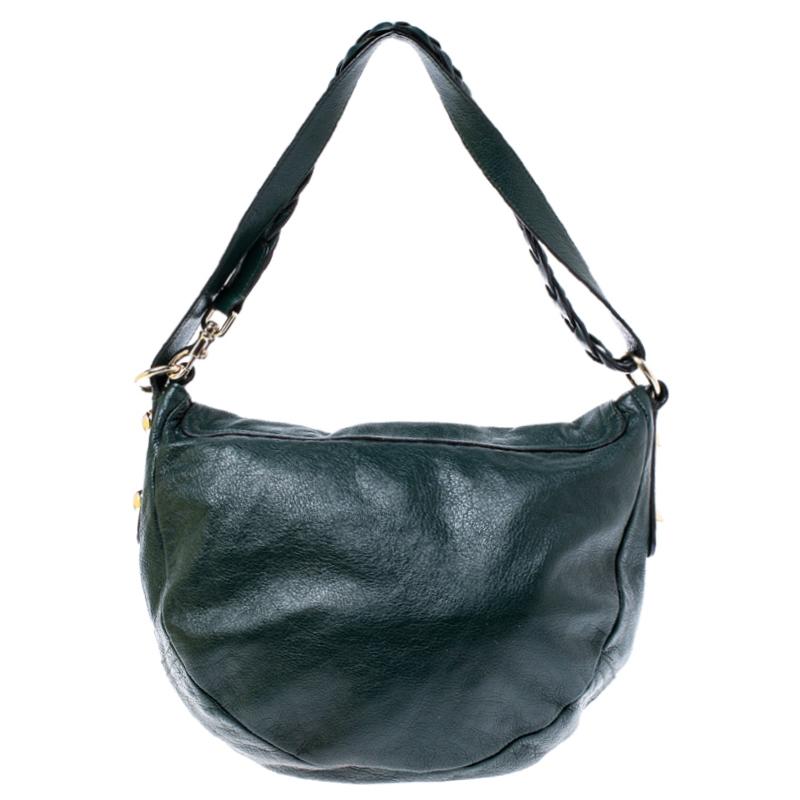 Invest in this Daria bag by Mulberry that is crafted from dark green leather. The bag has the brand label plate on the front flap that opens to a spacious fabric-lined interior housing a zip pocket. It features a shoulder strap that is half braided