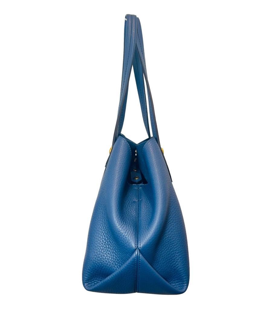 Mulberry Grained Leather Tote Bag

Royal blue tote bag detailed with gold hardware with 'Mulberry' engravements.

Featuring dual top handle and detachable, adjustable shoulder strap.

Designed with snap centre closure and sides of the bag snapped to