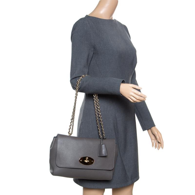 This Mulberry Lily bag is a classic. Crafted from leather, the grey coloured bag comes with a chain and leather woven strap. It has a postman's lock and the front flap opens to a suede lined interior. Carry it for your fashionable outings and let it