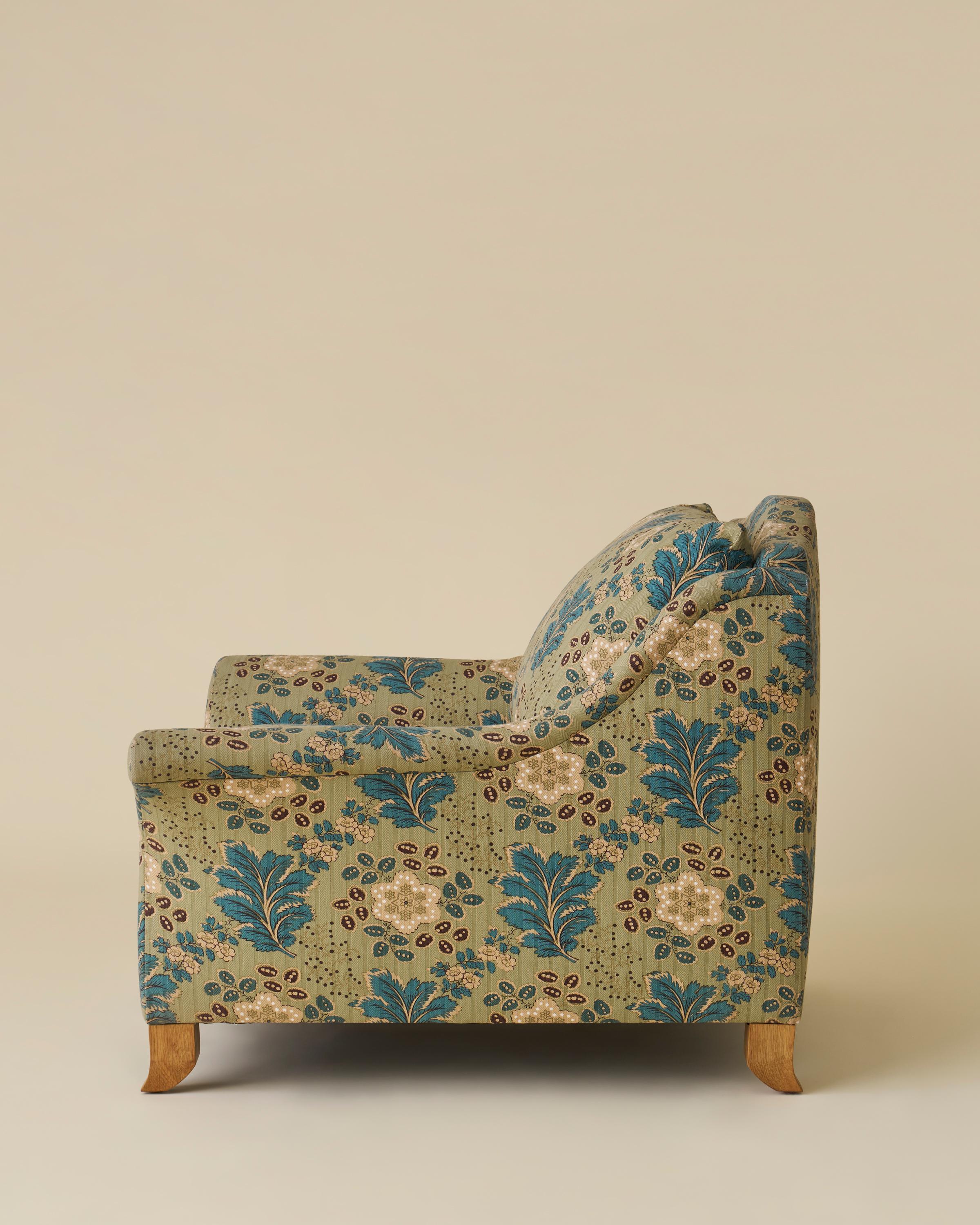 Camelback lounge chair with a swept-out, flared arm and solitary seat and back cushion. Shown in Jasper Ondine Teal and White Oak. 