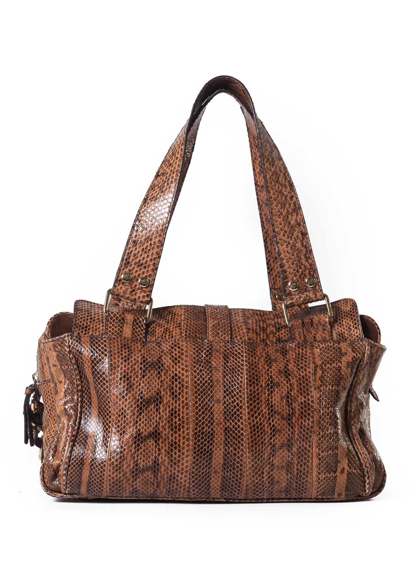 This Mulberry Bowling bag is made of python skin and features two exterior zip pockets and two exterior slip pockets with suede lining, an interior zip pocket, lined in Mulberry’s signature fabric, and large statement gold toned hardware. 

COLOR: