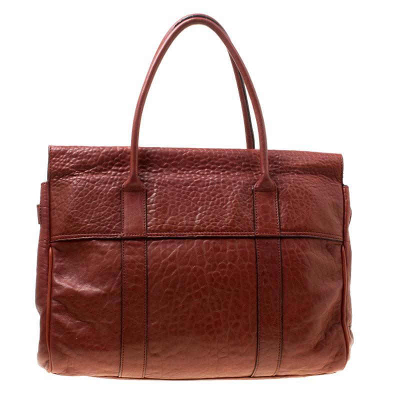 Satchels like these are hard to come by, so quickly grab one when you can. Crafted from textured leather, this Mulberry bag is equipped with dual top handles, a leather tag and protective metal feet at the bottom. The turn lock closure opens to a