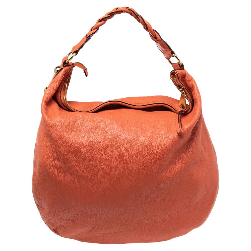 A bag as lovely as this one from Mulberry surely deserves to be in every woman's closet. It is made from orange leather and flaunts the brand logo plaque on the front. The zip closure opens to a well-sized fabric interior and the bag is complete