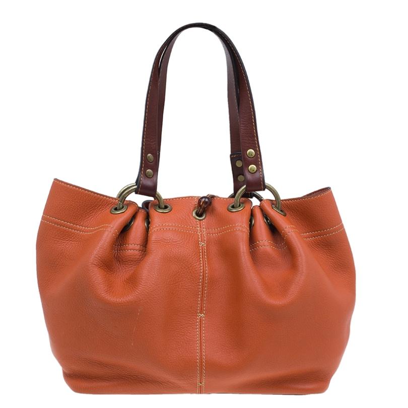 This exquisitely designed tote by Mulberry looks chic for a daily pairing up with casuals. Crafted from orange leather, this Matt Glove Judy tote bag is certainly splendid. It features contrasting handles with a minimal gold-tone detailing and