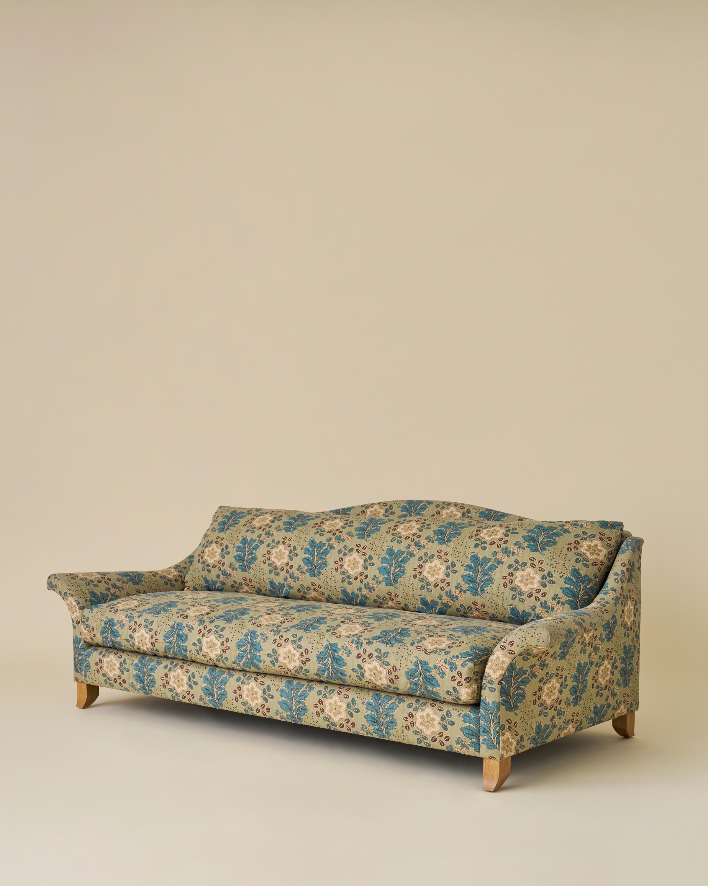 This classic camelback sofa with a dramatic, swept-out, flared arm and a flared solid oak leg. The solitary seat and back cushion create a seamless and clean look. The piece is constructed with a solid oak frame. 

Shown in Jasper Ondine Teal and