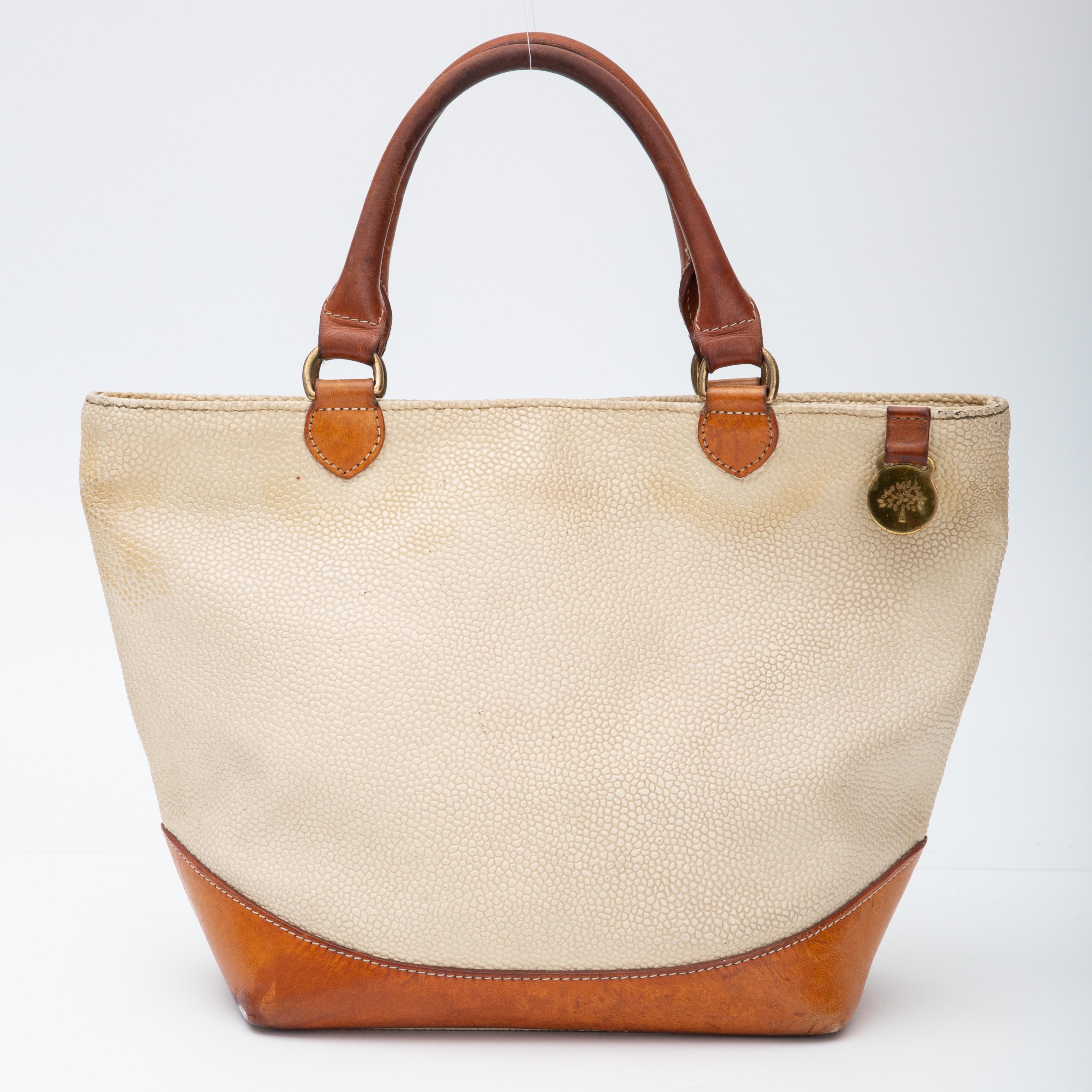 COLOR: Beige/cream
MATERIAL: Pebbled leather
MEASURES: H 5” x W 12” x D 5”
DROP: 5”
CONDITION: Good - vintage bag with imperfections throughout including darkened top handles, light marks and scratches.

Made in England