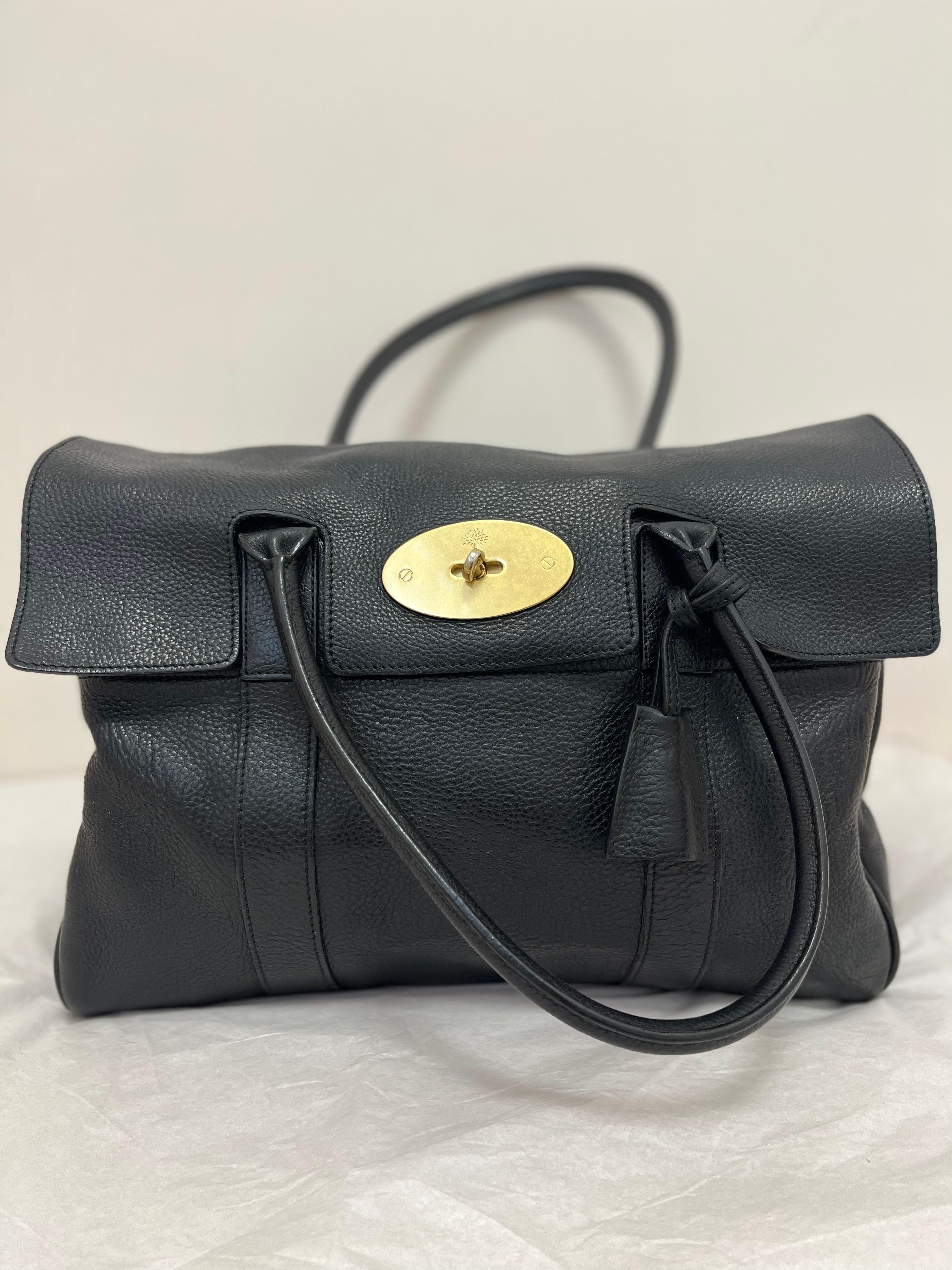 Made in England and in beautiful condition, this Mulberry Classic is made of grained leather. It has fold over flap with a turn lock closure; suede lining with internal logo pouch and slip pockets; brass hardware; interior belted sides which can be
