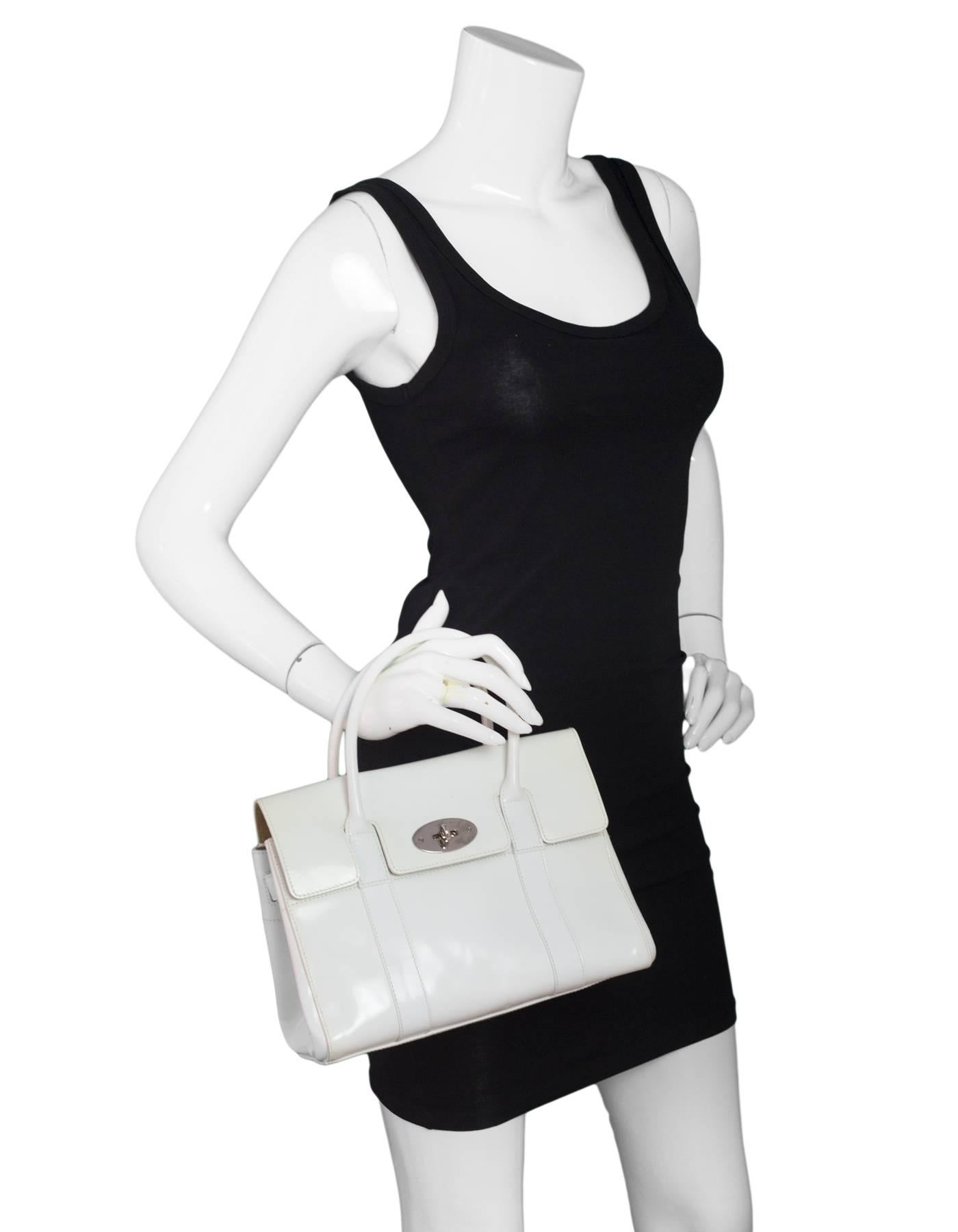 Mulberry White Patent Leather Small Bayswater Bag

Color: White
Hardware: Silvertone
Materials: Patent leather
Lining: Beige textile
Closure/Opening: Flap top with center twist lock
Exterior Pockets: None
Interior Pockets: Zip wall pocket, wall
