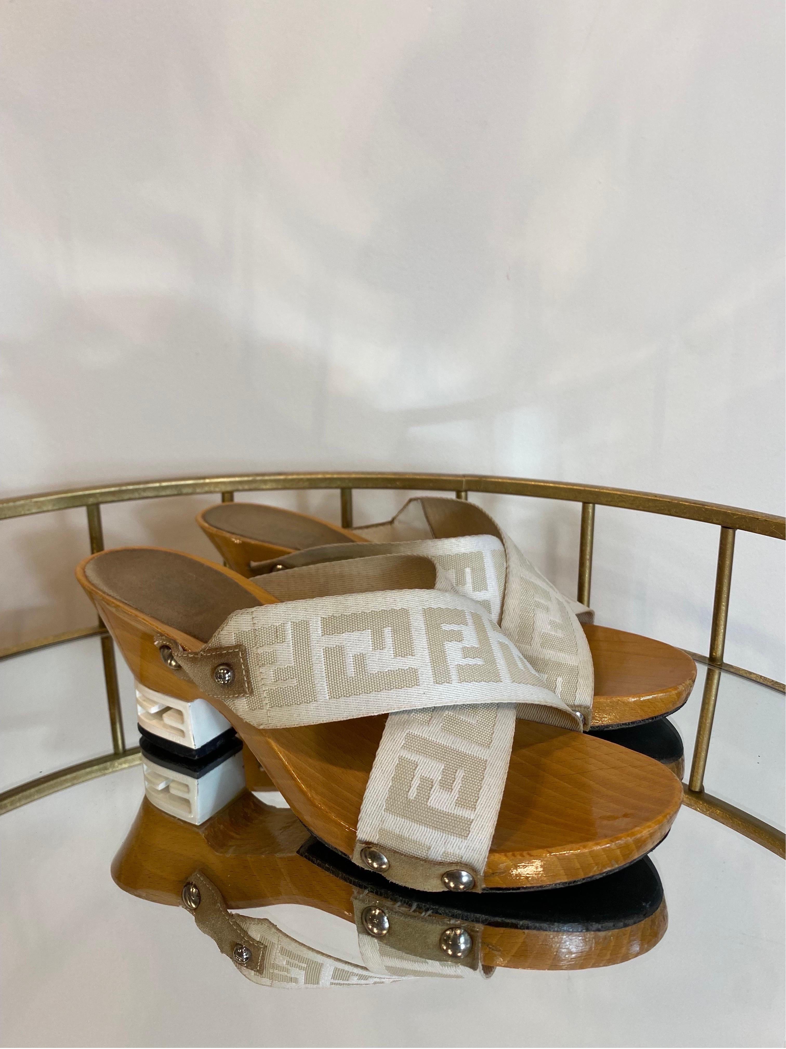 Zuecos Fendi
En lona beige con logotipo. Con inserciones de ante en la suela de madera. 
Número 37 italiano.
Altura del tacón 7 cm
Longitud de la suela interior 24 cm.
En buen estado general, presenta signos de uso normal.