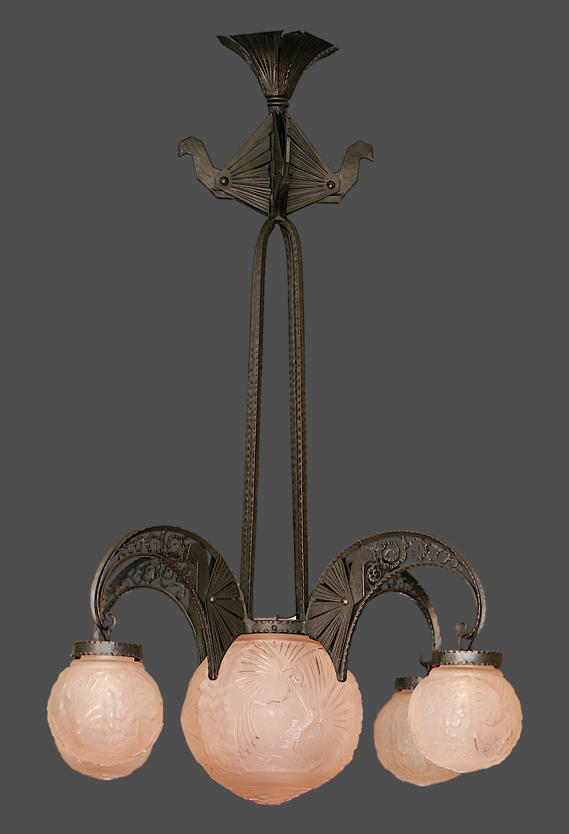 Splendido lampadario decorato con pavoni di Muller Frères (vetro) e Andre Kovacs (struttura in ferro battuto), anni Venti. La vetreria è composta da quattro sfere di vetro più una centrale più grande. Ogni paralume di Muller Freres raffigura 6