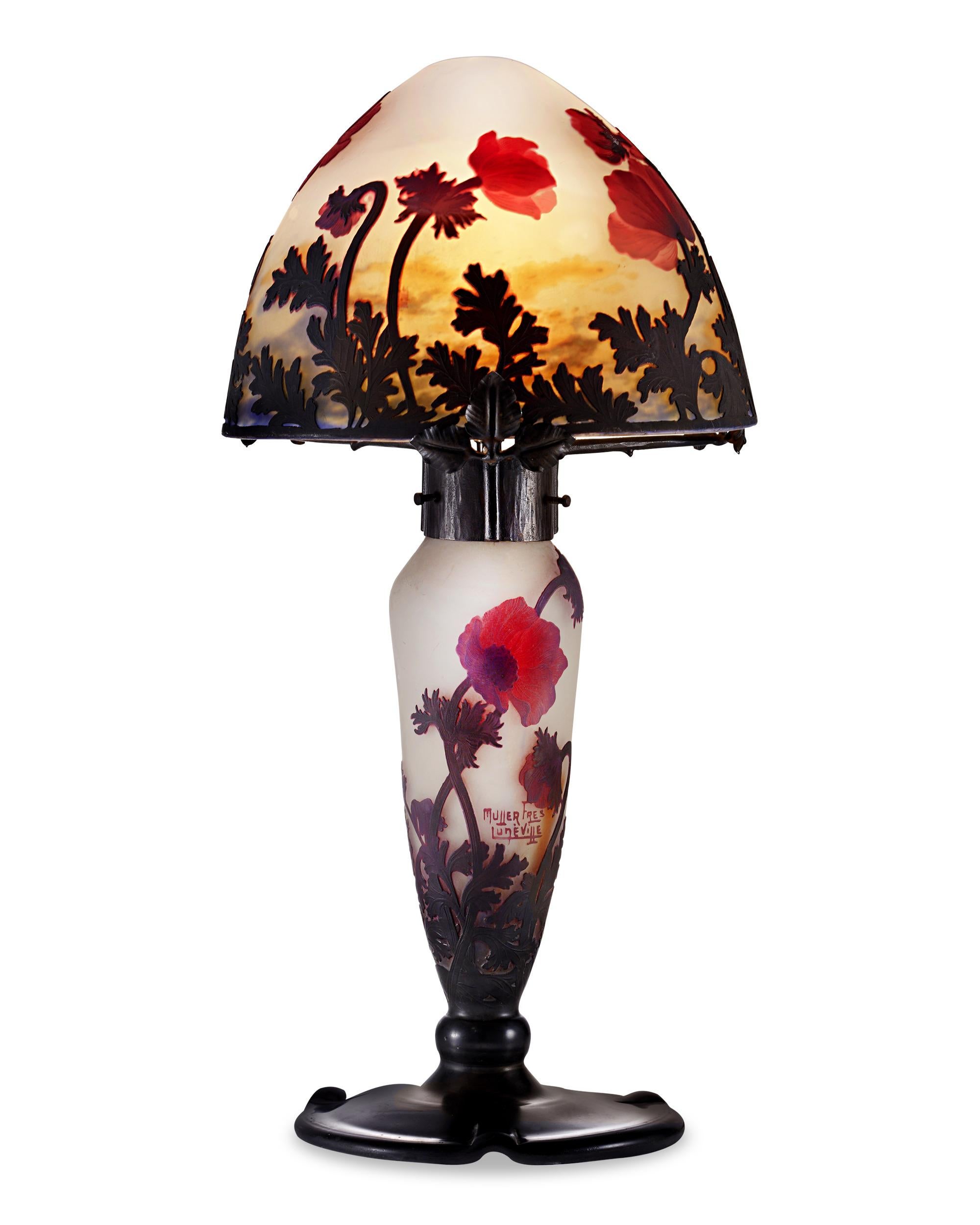 This stunning cameo glass lamp from the celebrated Muller Frères glassworks is an exceptional example of the art form. The shade and base are executed in elegantly frosted glass, which allows the beautifully detailed anemone blooms that encircle the