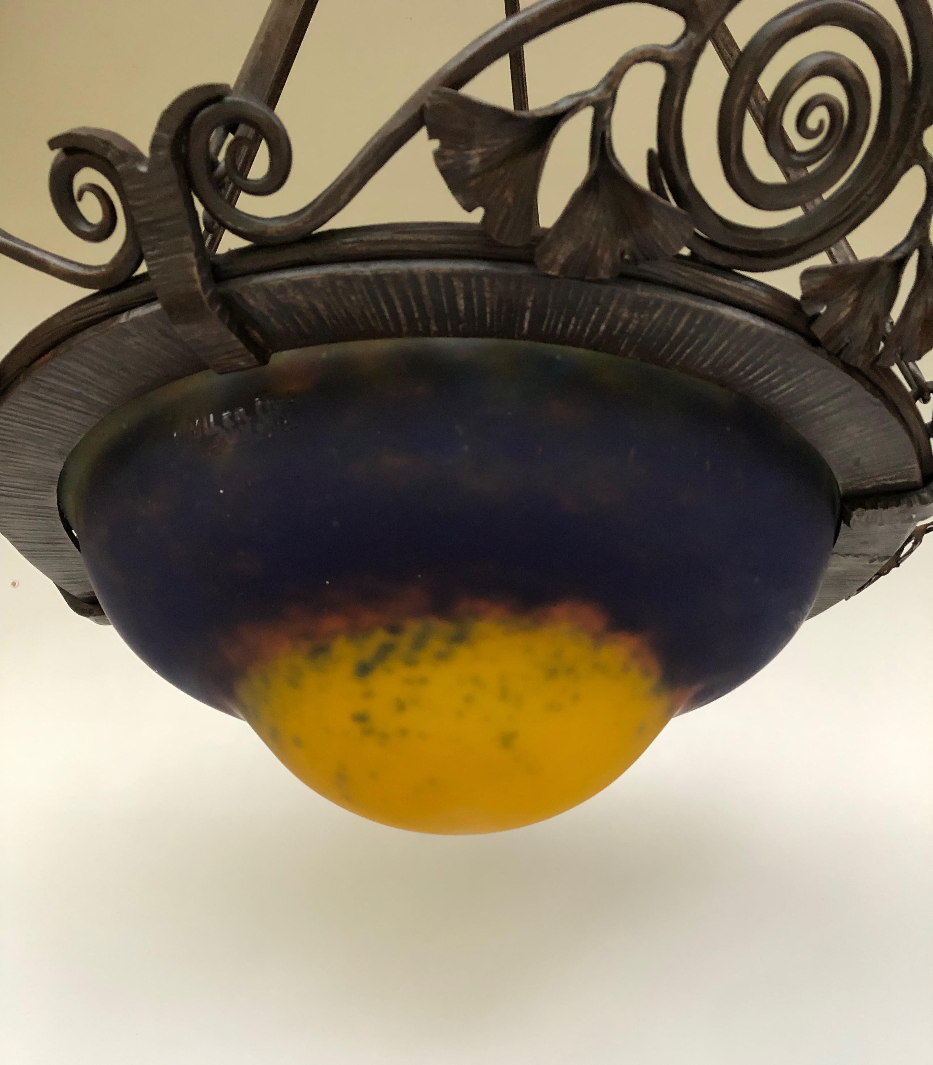 Art deco hanging lamp, circa 1920. Wrought iron frame. Decorated with ginkgo biloba leaves of very good workmanship.
Basin in speckled glass paste. 
Signed on the bowl Muller Frères Luneville.
Electrified and in perfect condition.

Total height