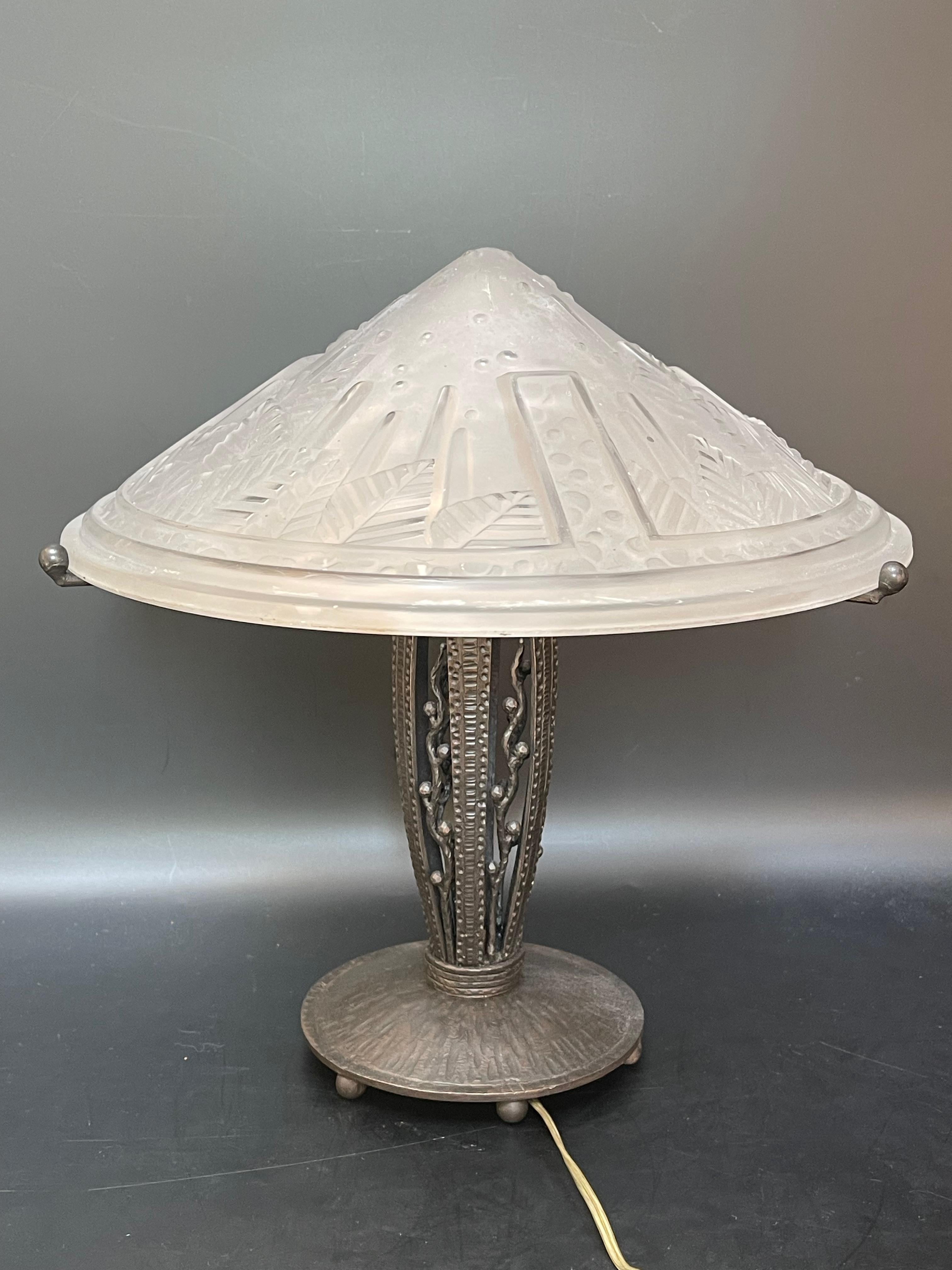 Art deco lamp circa 1930.
Wrought iron foot and molded glass shell signed Muller Frères.
Electrified and in perfect condition.
Diameter: 14 cm (base) 
Diameter: 31 cm (obus)
Height: 31 cm
Weight: 3,1 Kg

The Muller brothers, founders of the Muller