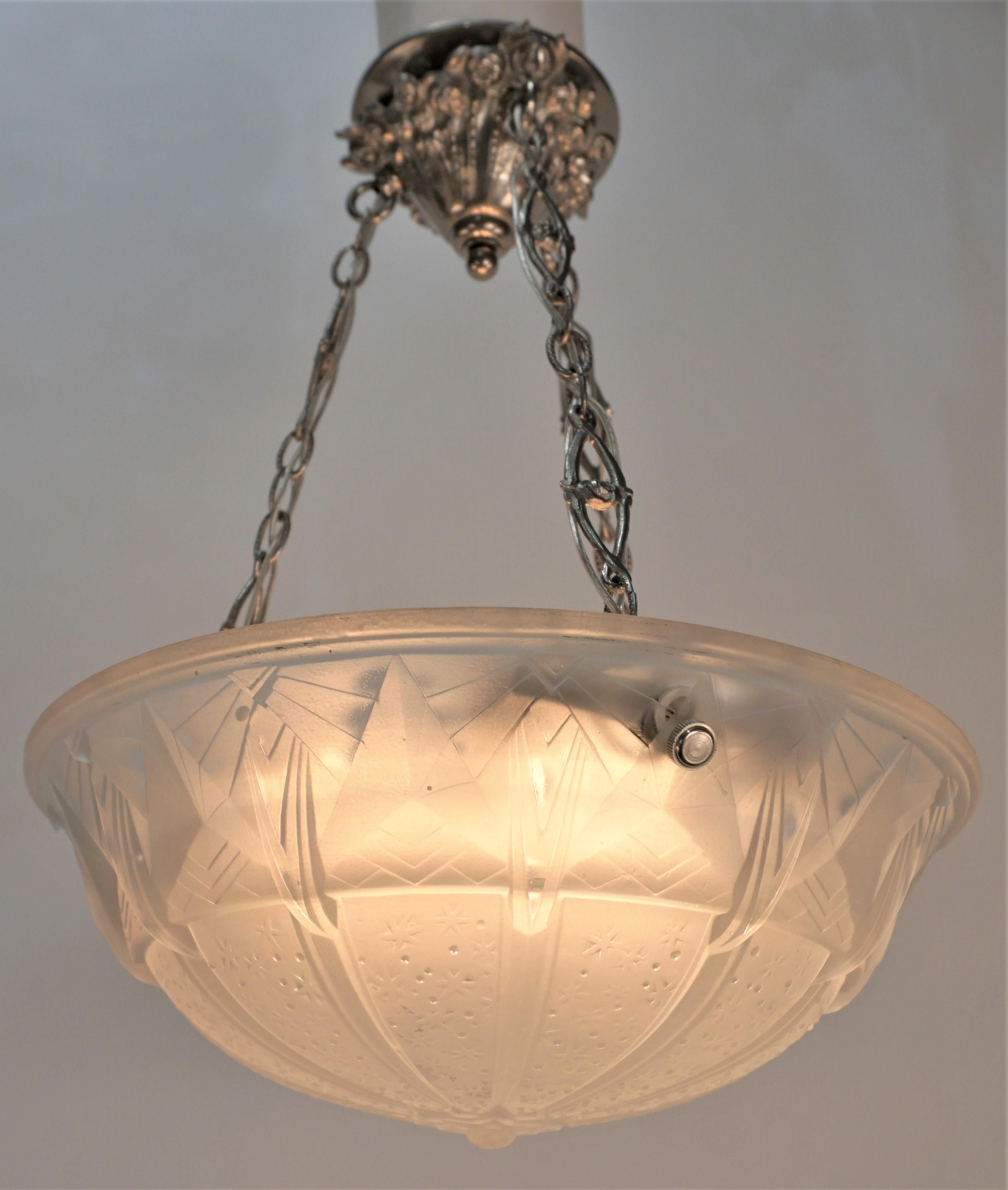 Muller Frères Art déco verre clair dépoli avec quelques verres polis à haute luminosité dans un motif géométrique avec une chaîne et un baldaquin en nickel poli.
Recâblage professionnel et prêt à être installé.
Six lampes de 60 watts maximum