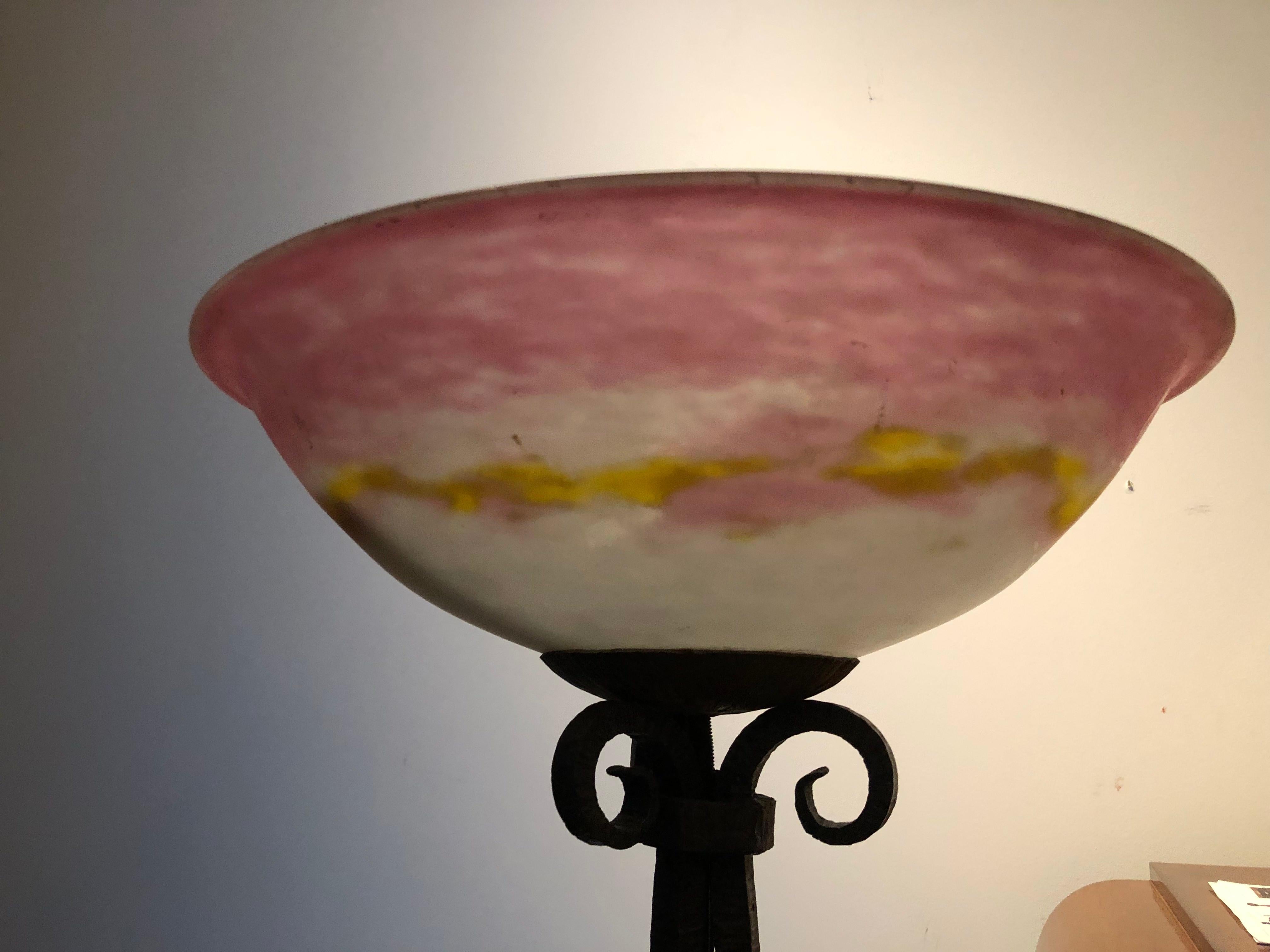A Muller Frères glass and wrought iron floor lamp in colorless glass with pink and yellow powders on a patinated wrought iron base decorated with vine branches. Glass marked Muller Frères Luneville.